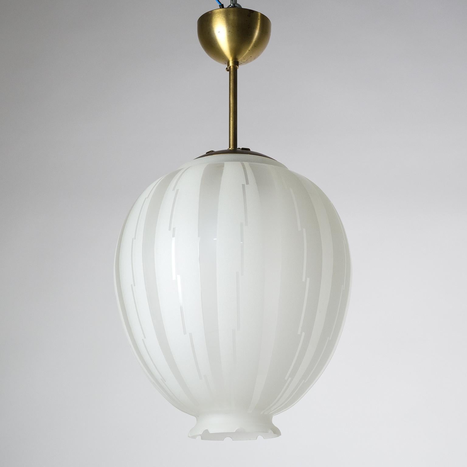 Rare Art Deco glass and brass pendant, Sweden 1930s. The balloon shaped glass body has a satin finish on the inside and is partially satinated on the outside in a pattern of stripes and geometric lines with a lovely contrast of matte and glossy