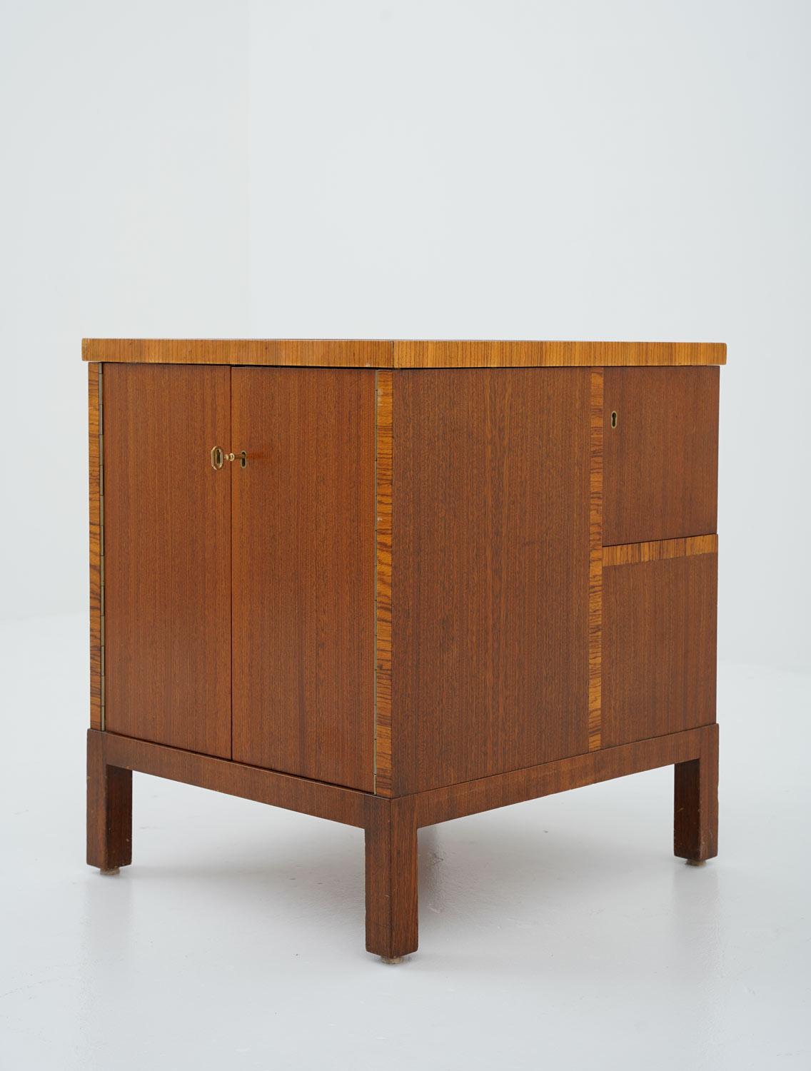 Elegant side table or bar table manufactured in Sweden, 1930s.
This table is made with impressive craftsmanship. The sides of the table offer several shelves and lockers and are veneered with mahogany and Zebrano. On the tabletop, you will find