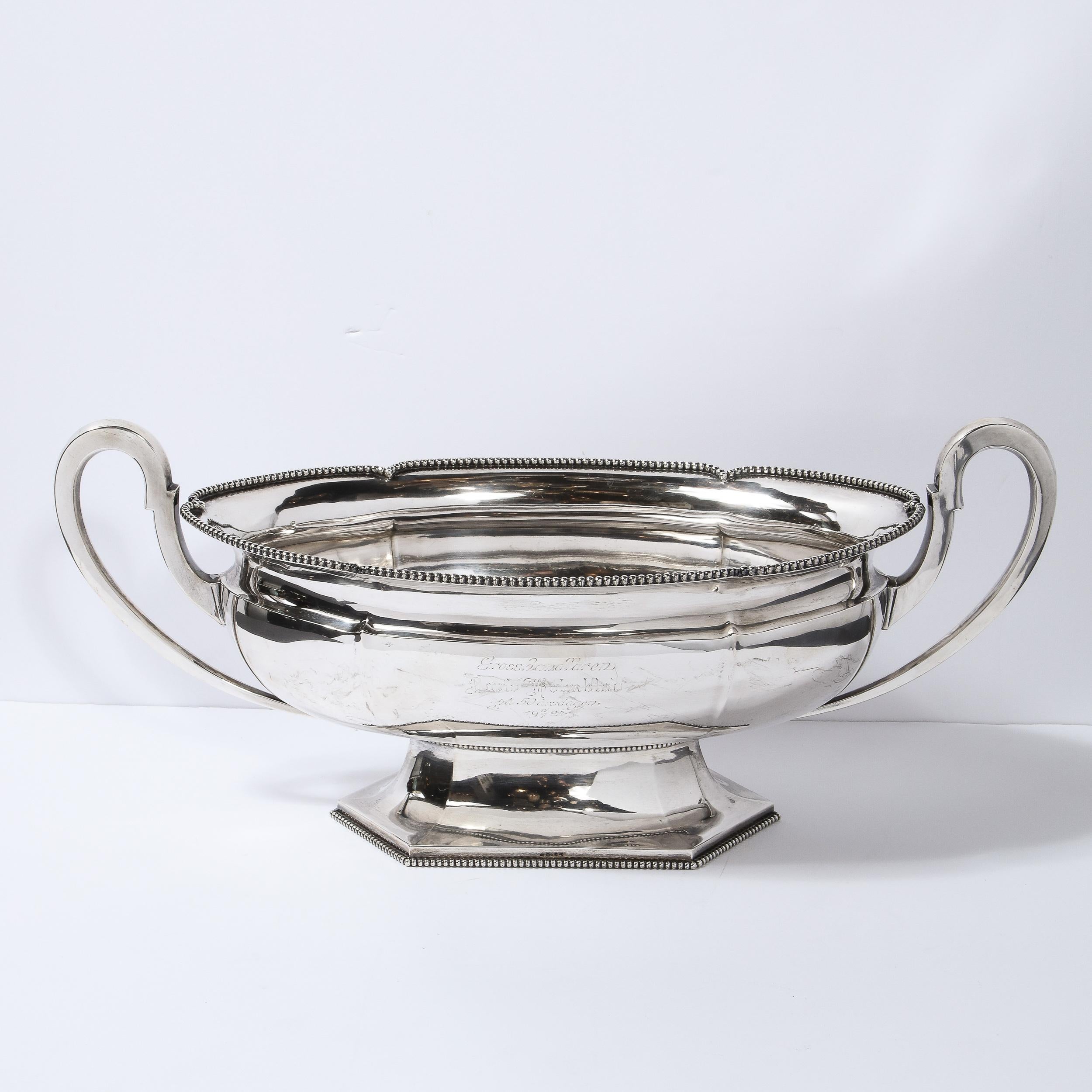 This elegant Art Deco trophy bowl was realized in Sweden in 1924. It offers a sculptural oval body sitting on a hexagonal faceted base with beaded detailing around the perimeter- all in lustrous silver plate. The top of the piece also has beaded
