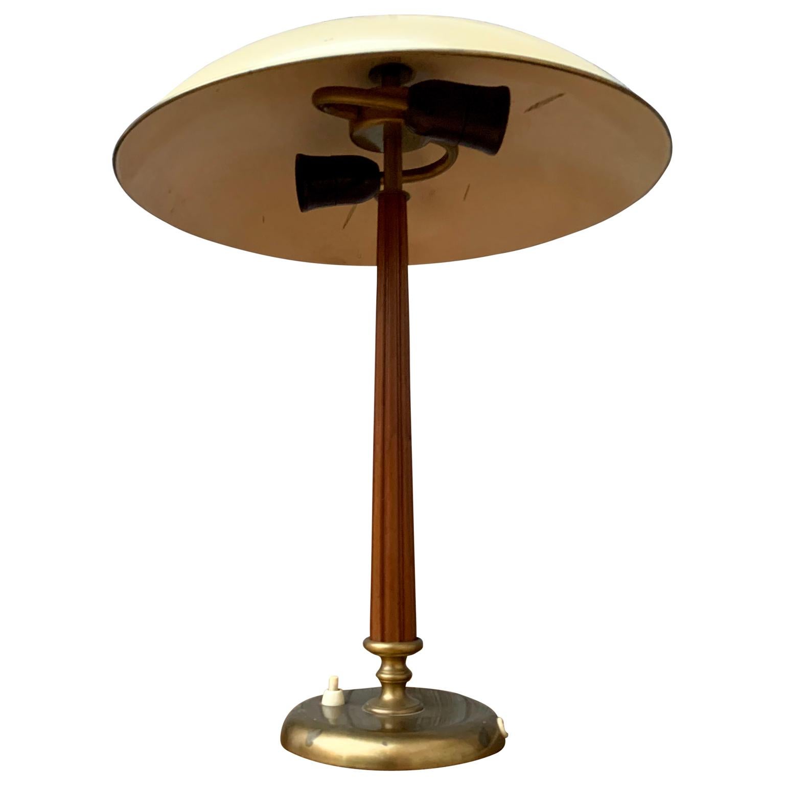 A Swedish Grace-period Art Deco table lamp in original un-touched patina. The lamp is made in brass, mahogany and creme-colored lacquered metal. From circa 1940 and attributed to designer Harald Notini out of Stockholm for 