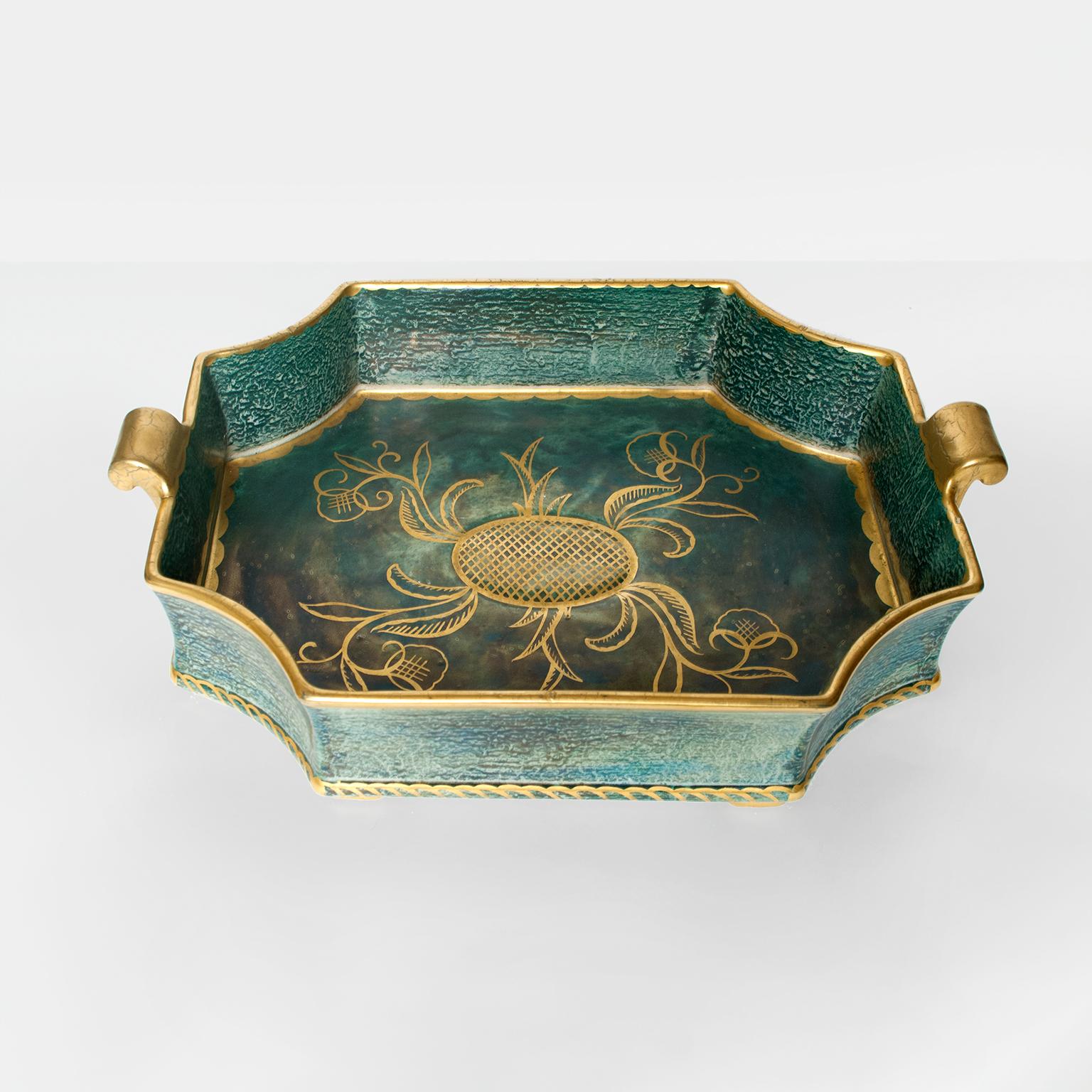 Large Swedish Art Deco tray or bowl with notched corners and handles. Hand decorated with gold glaze over a blue and green luster glaze. Designed by Josef Ekberg for Gustavsberg, signed and dated 1929.