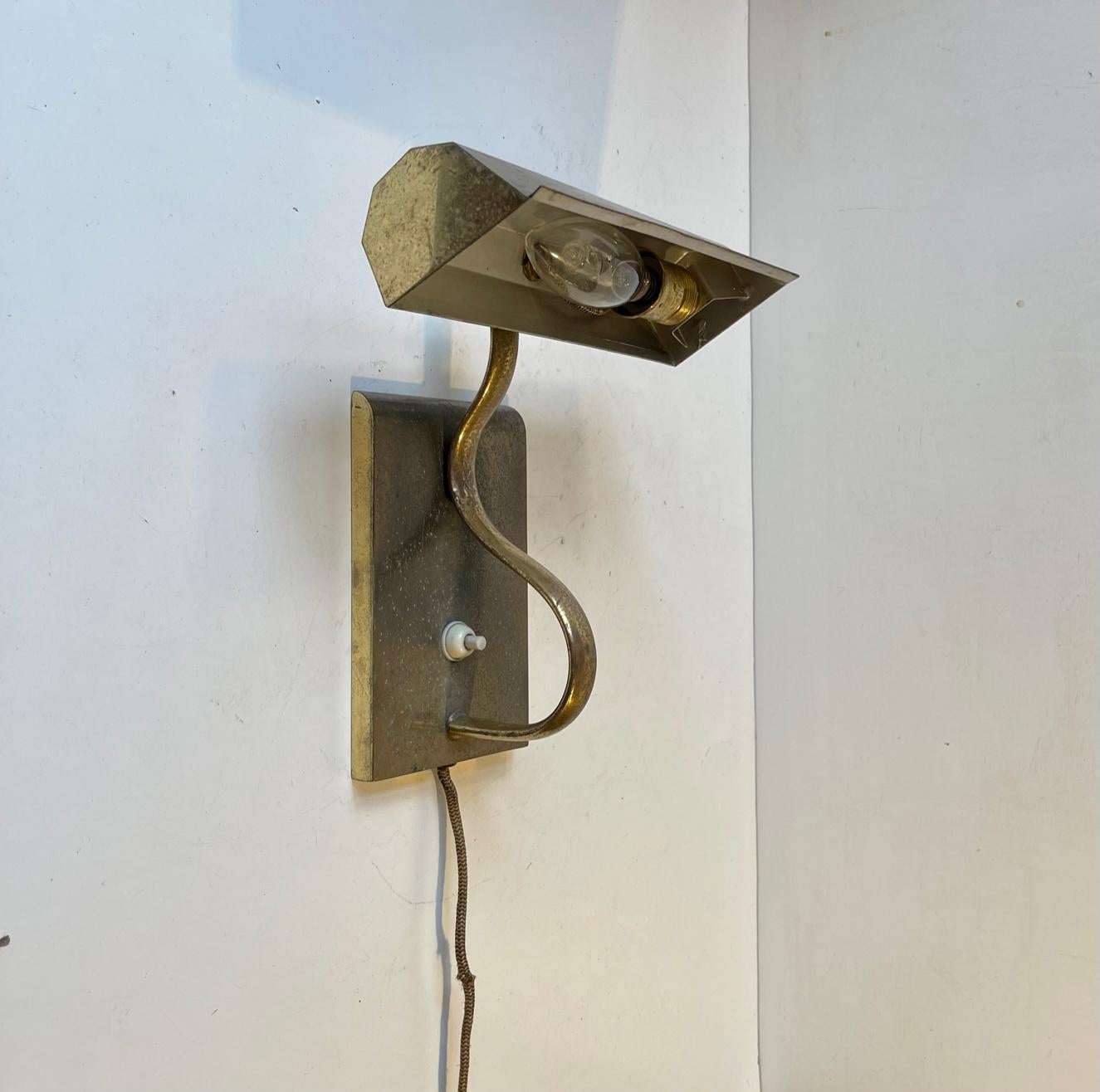 A fine 1930s Wall light in solid patinated brass. Made in Sweden during the 1930s, probably by ASEA, in a style reminiscent of Vilhelm Lauritzen and Louis Poulsen. Art Deco - Functionalist. It is adjustable at the faceted shade and features on/of