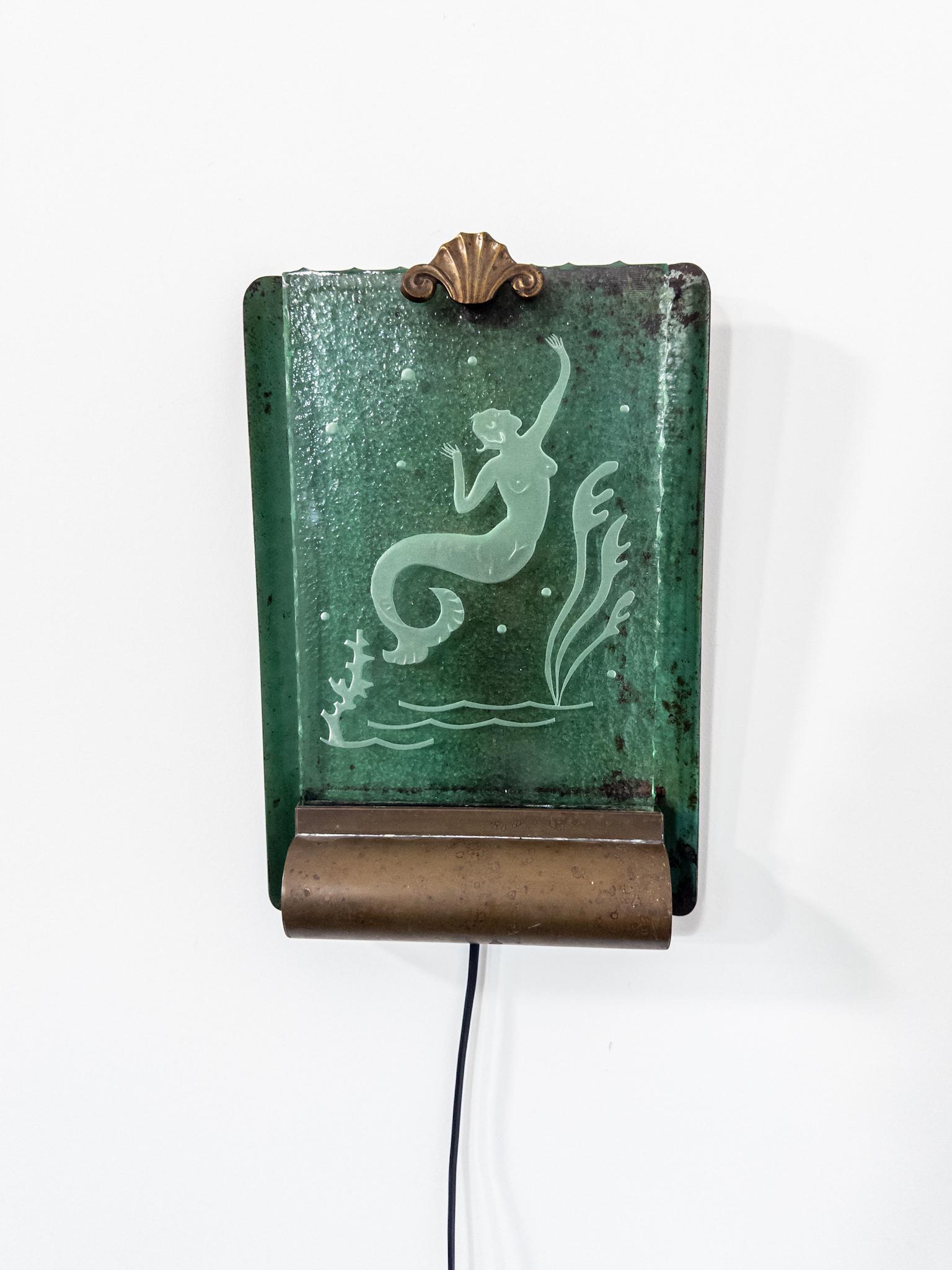 Una rara y cautivadora lámpara de pared Art Decó sueca, probablemente fabricada por Glössner en los años veinte o treinta. Esta asombrosa pieza está hecha de cristal con textura en bruto (råglas) con un bello motivo de sirena grabado, que irradia