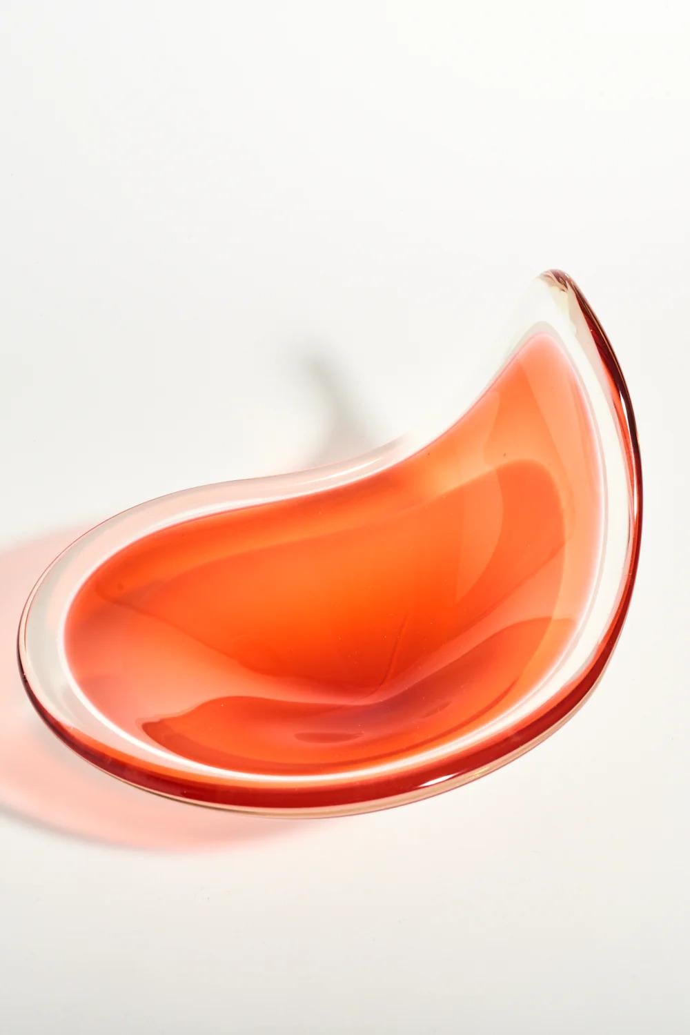 Beautiful Swedish art glass bowl, graceful wave shape, lovely blood-orange color tones framed in clear glass. 

