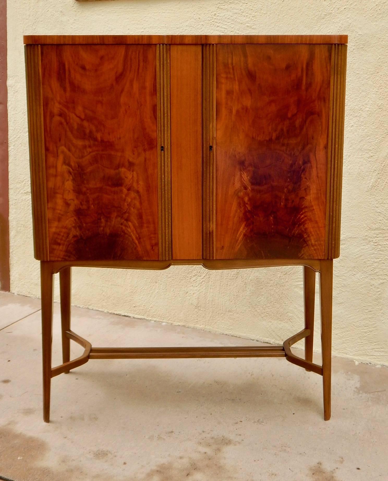 Swedish art moderne bar cabinet by Reimer's Möbler, Mjölby. Rendered in highly figured Santo Domingo mahogany. Interior is composed of adjustable shelves and some of the most beautiful drawers we have ever seen. Date stamped 1948. With maker's stamp