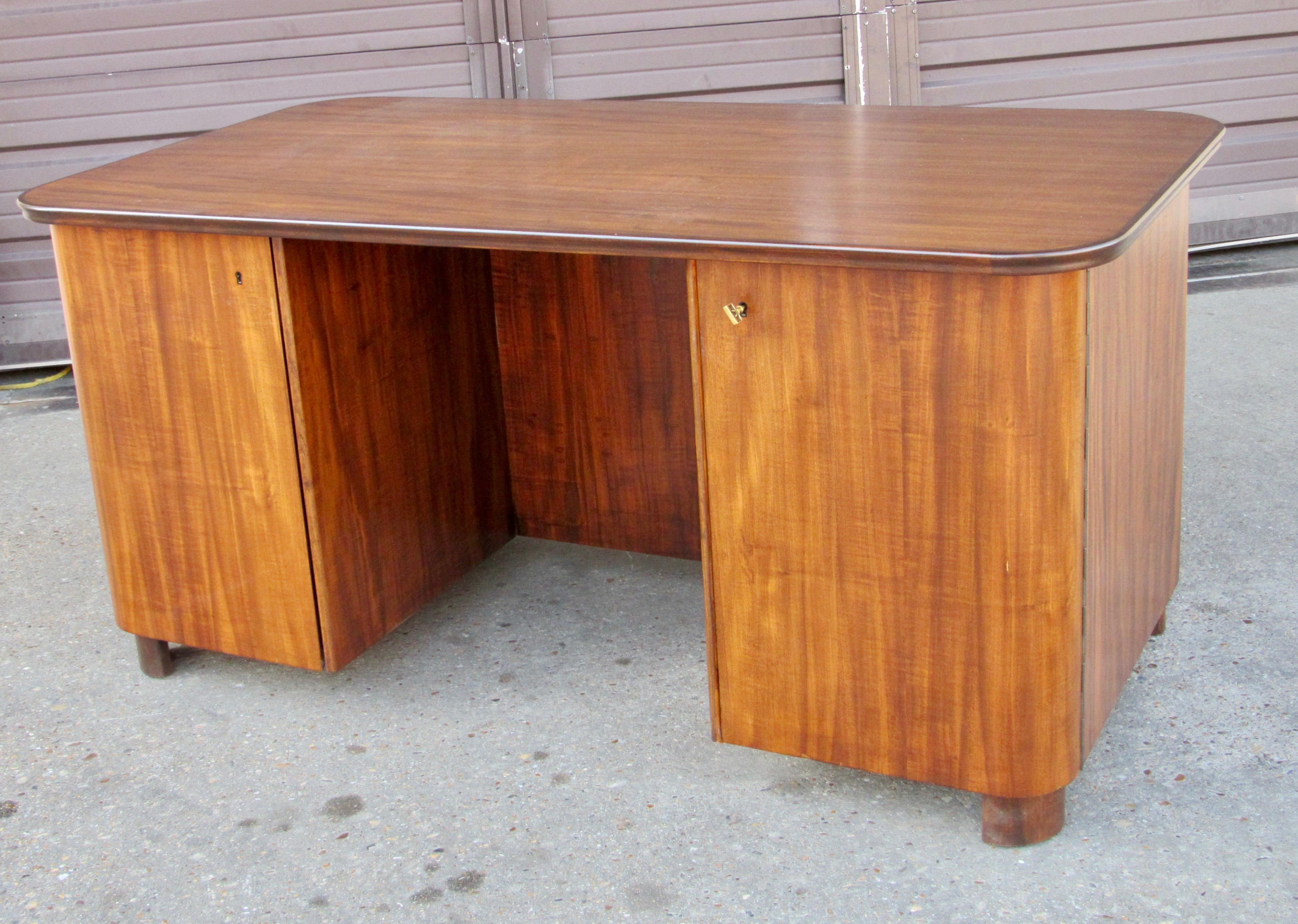 Swedish art moderne desk.
Rendered in walnut with mahogany banding. 
Interior with shelves and pull out drawers.
Back is an exposed book case.
This desk has been beautifully refinished by our craftsmen.
Made in Stockholm, Sweden circa 1940