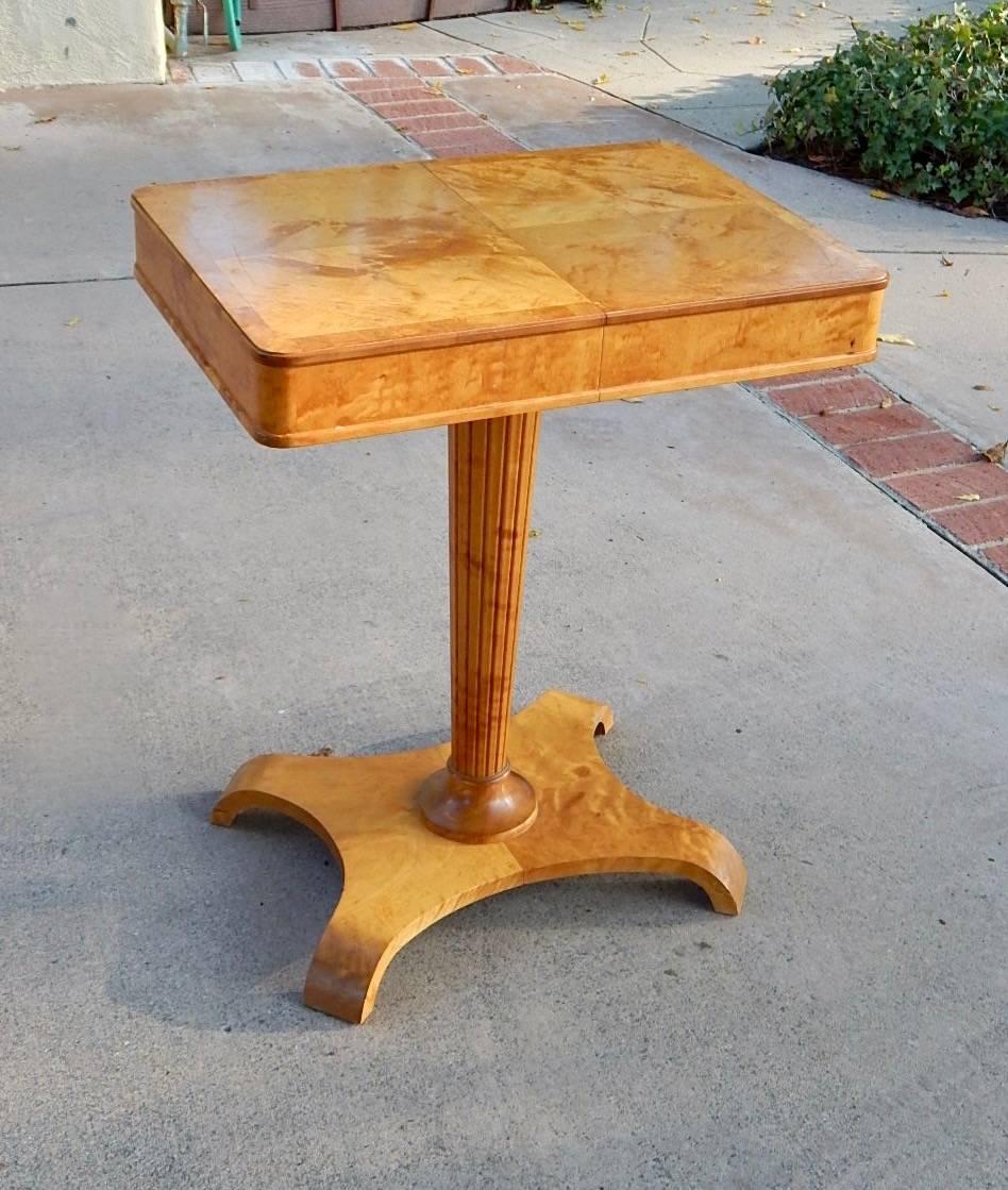 Swedish art moderne side table rendered in highly figured golden flame birchwood. Designed by Axel Larsson for Bodafors ca. 1940.
Optionally, this table extends from 22