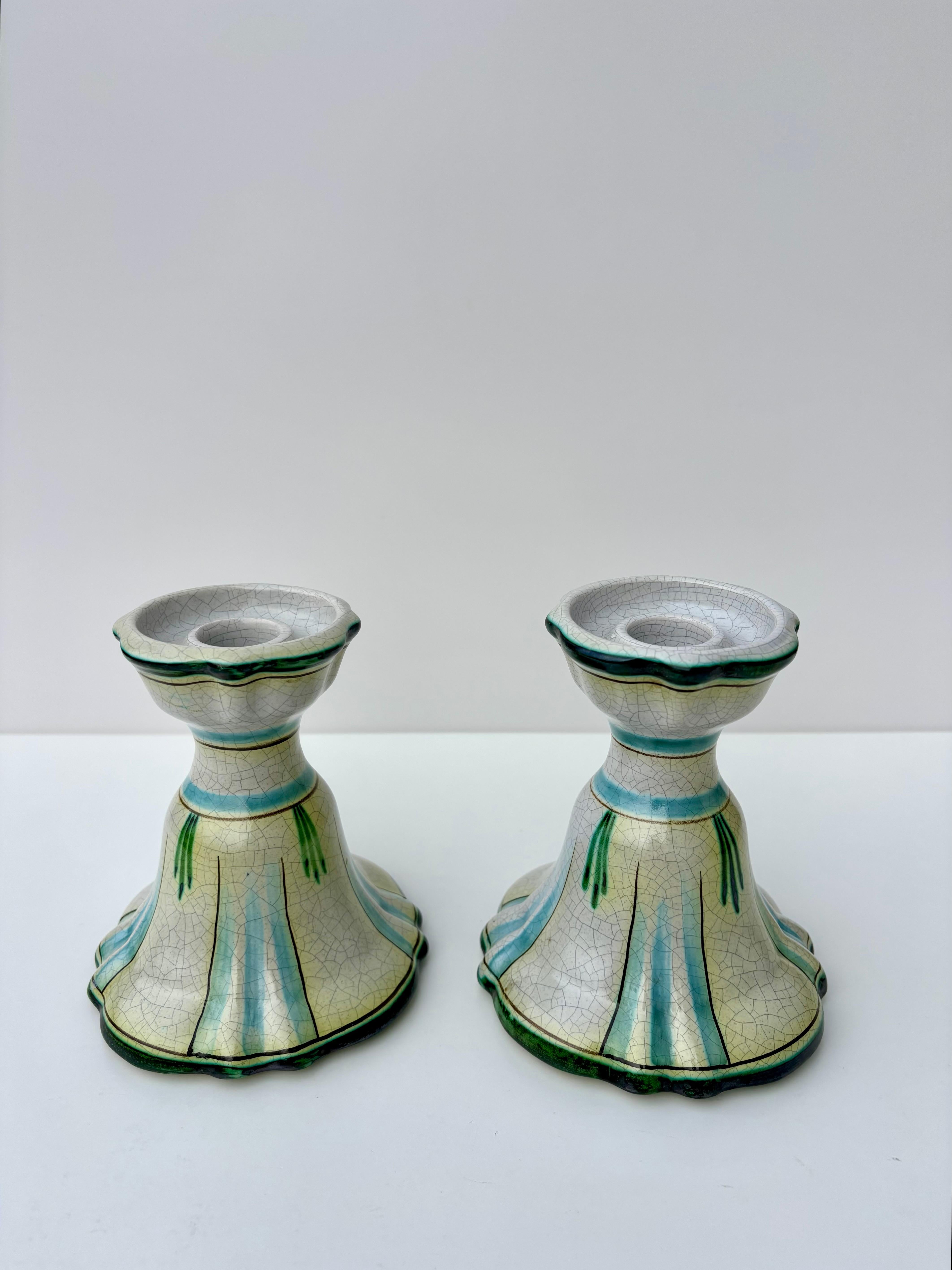 Set of antique Swedish Art Nouveau ceramic candle sticks by Allan Ebeling for Bo Fajans in the early 1920s. Light gray crackle glaze with green, yellow and light blue colored hand-painted decor.
Signed and numbered by artist.
Beautiful vintage