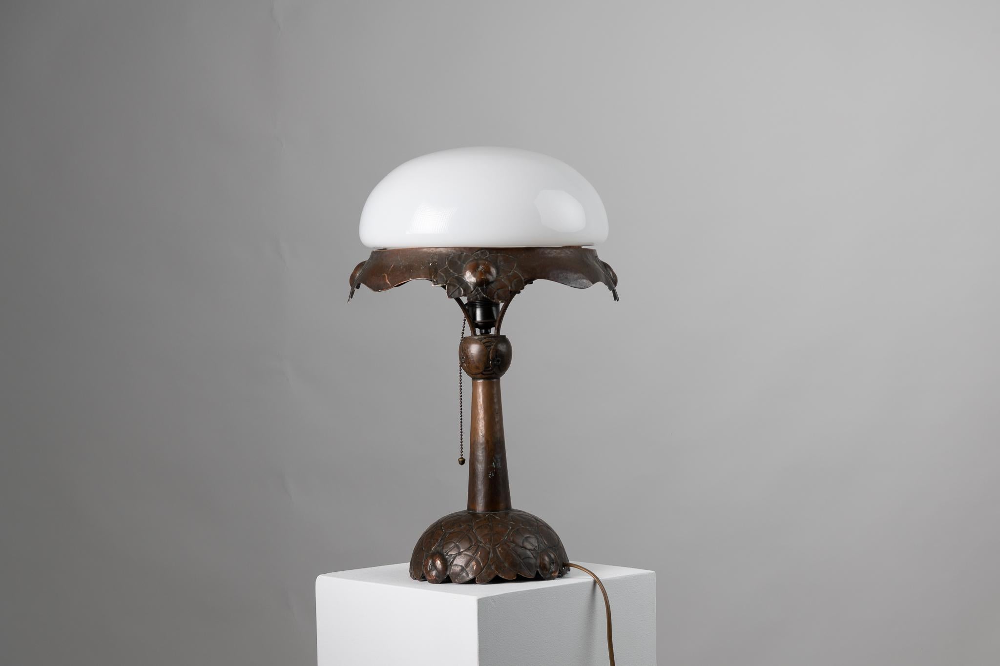 Art nouveau table lamp from Sweden. The lamp is from the early 20th century, from 1910 to 1915, and is hand made with a foot in solid copper. The whole lamp is decorated with typical art nouveau decor and reflects inspiration from nature with an