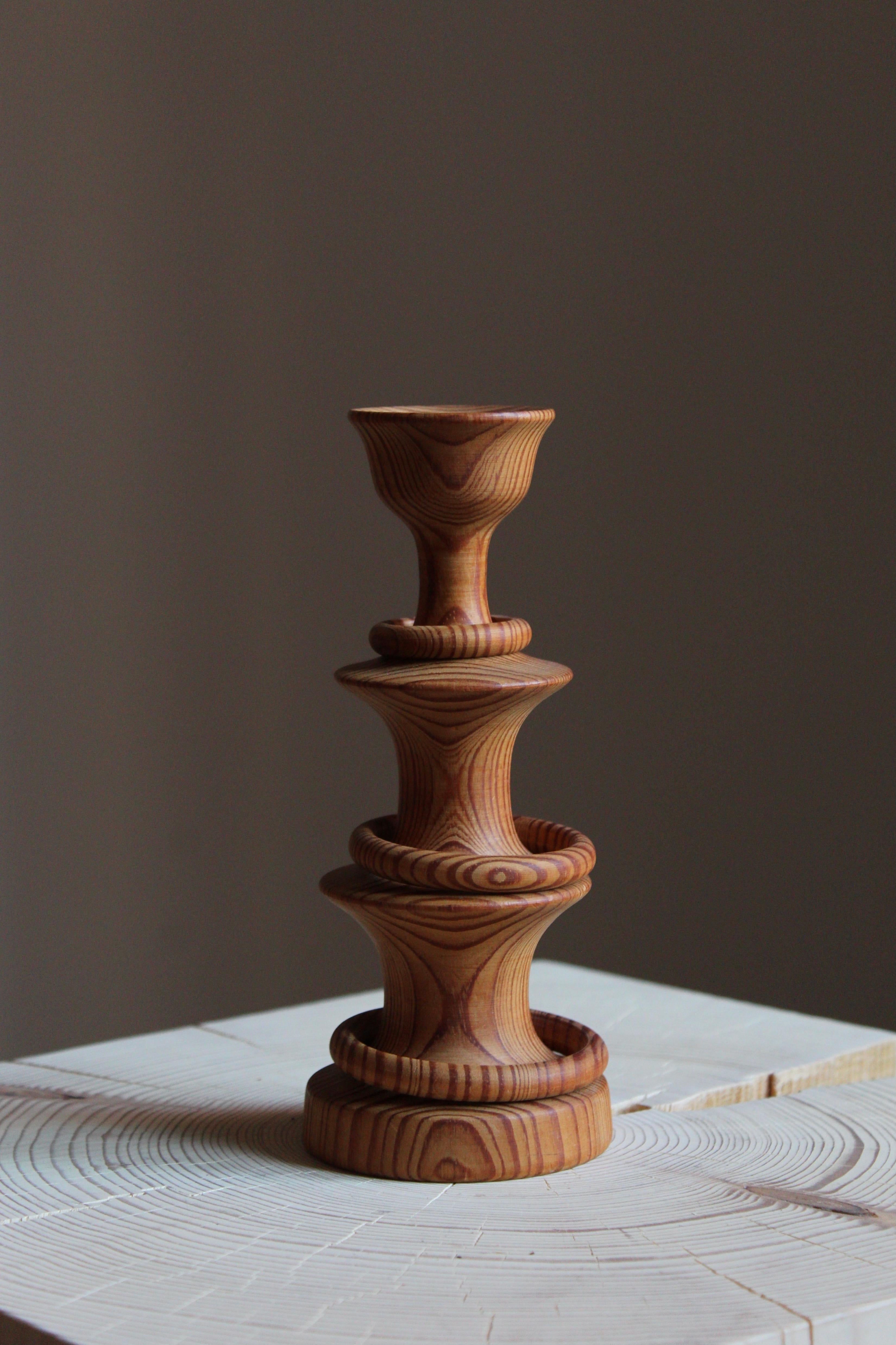 A studio candlestick, signed and dated 1973. Intricately and painstakingly carved out of one solid block of pine.