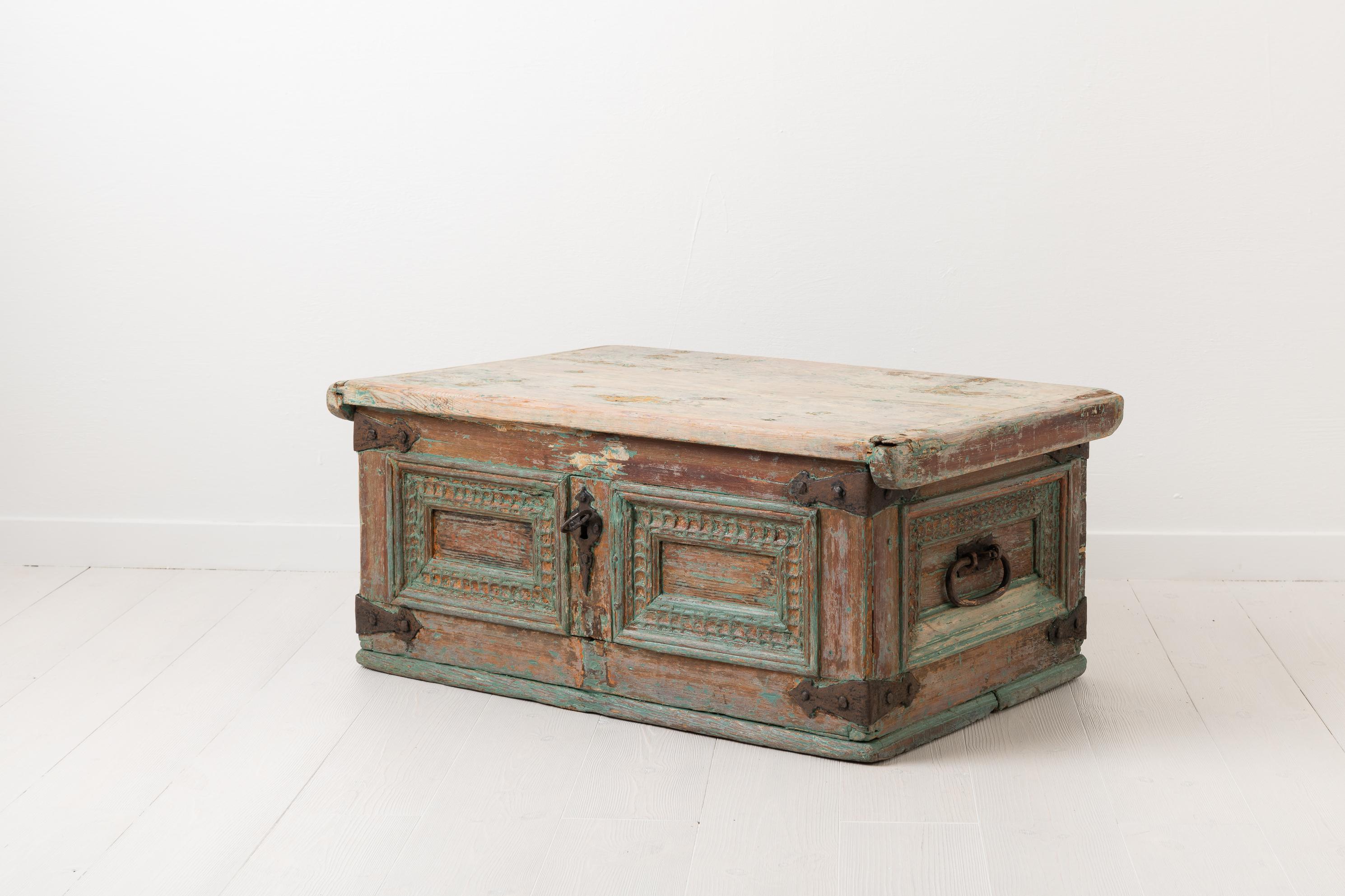 Swedish Baroque chest from the mid-18th century. The chest is handmade with hand carved decorations and details. The hardware and hinges are also handmade but in wrought iron. The chest has traces of the original paint from the mid-1700s. Over the