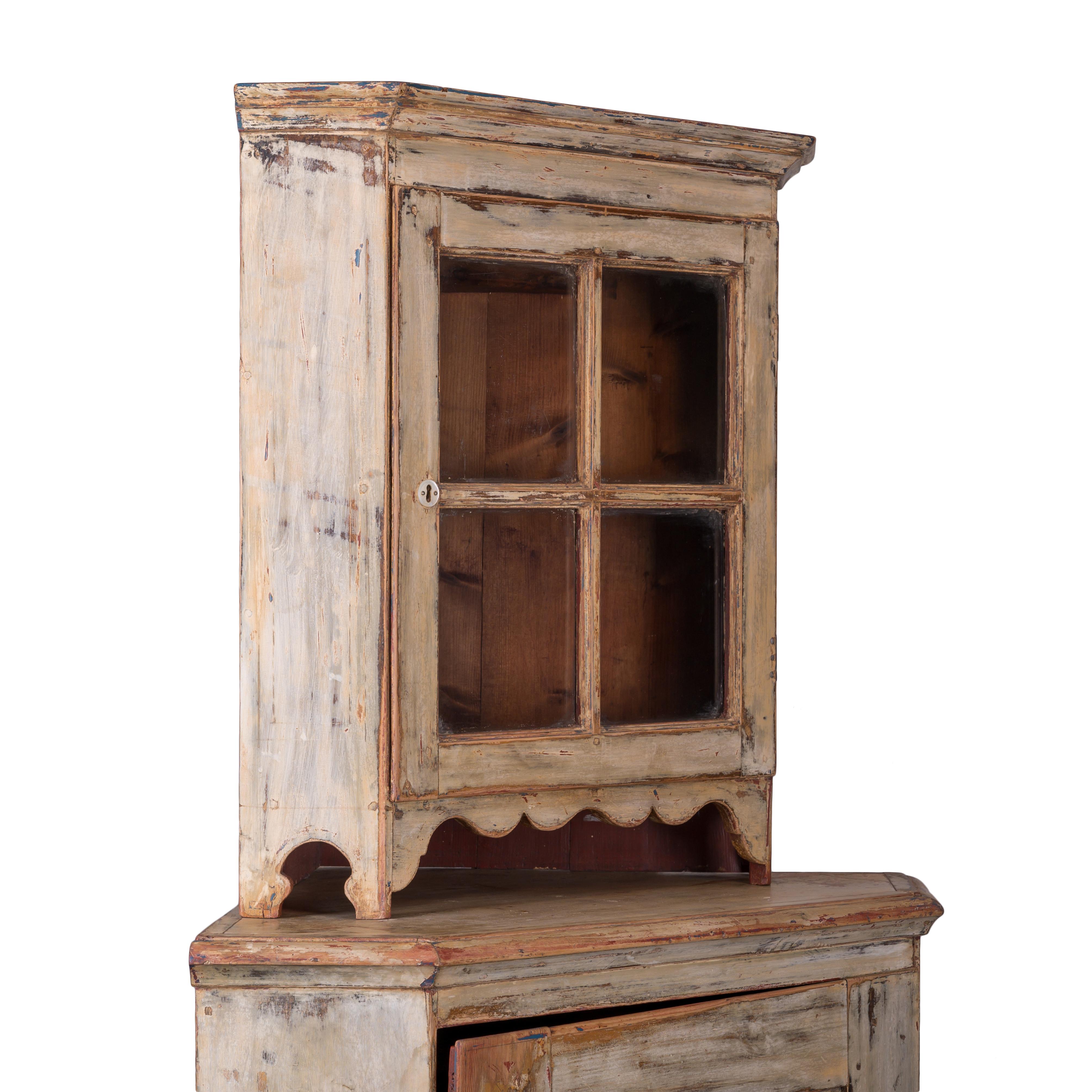 A Swedish baroque corner cupboard, mid-18th century.

Two pieces with smaller glazed upper cabinet and large lower cabinet.  Scraped back to cream white paint.

81 ½ inches tall by 29 ½ inches deep by 41 inches wide

Height of lower cabinet: 50 ½