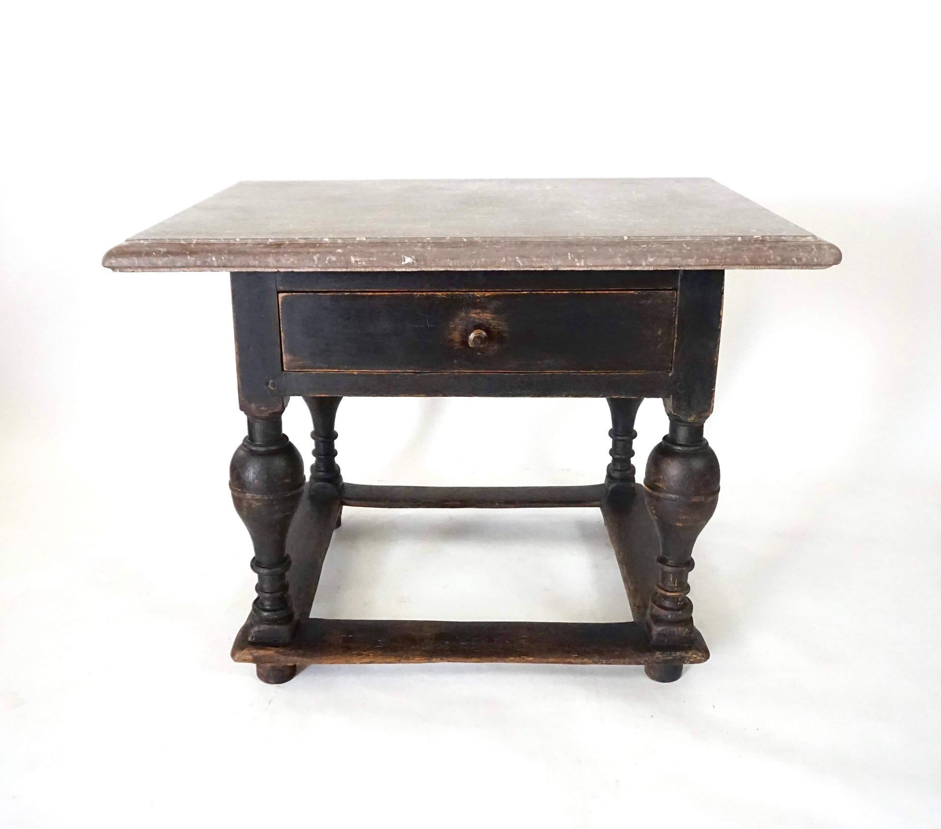A circa 1750 Swedish baroque period table with original spectacularly mottled Öland limestone top resting on oak base in original black paint with single drawer and stretchered baluster-turned supports. Would make an excellent baking or pastry table