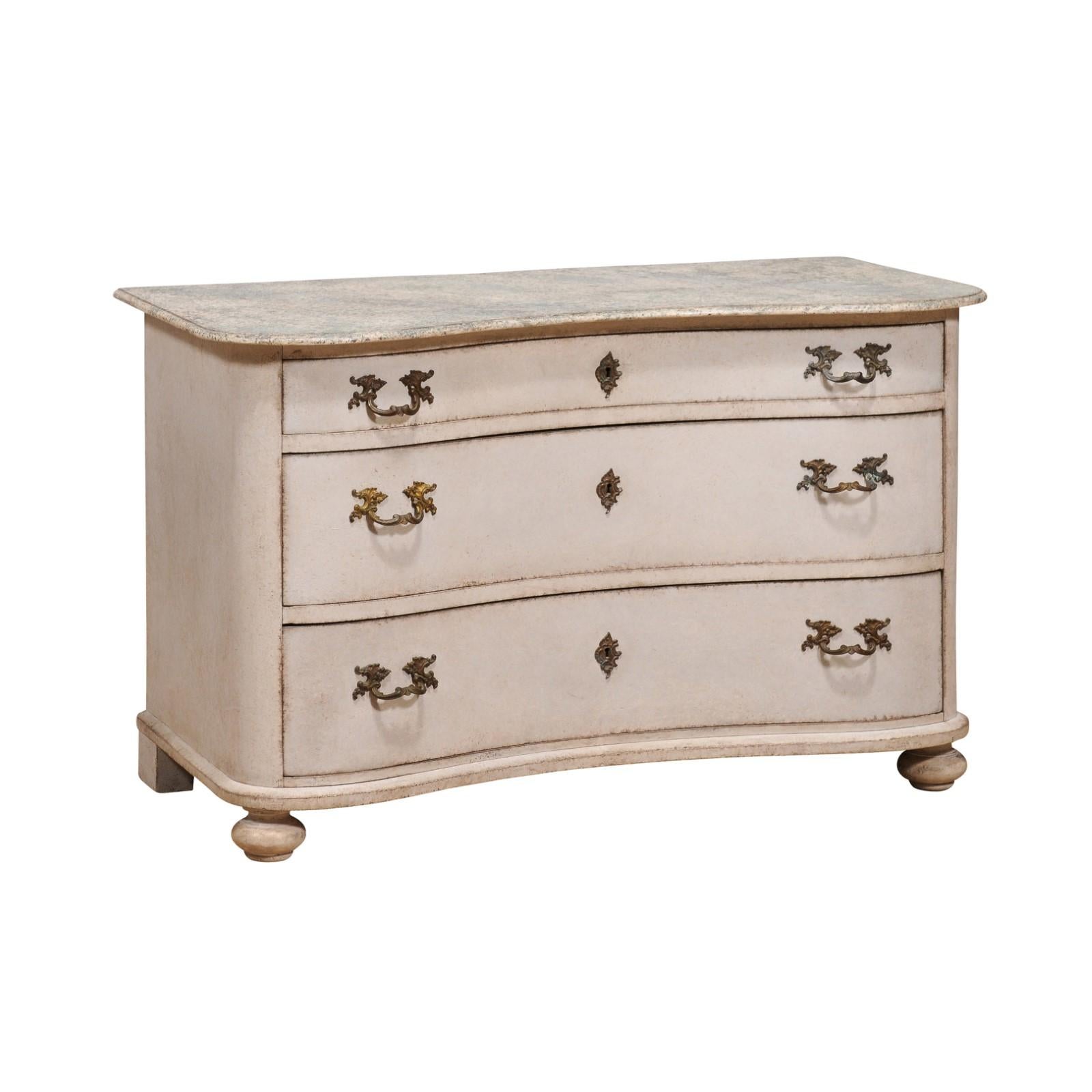 A Swedish Baroque style serpentine front three-drawer chest from the 19th century with light gray painted finish, marbleized top and turned feet. This 19th-century Swedish Baroque style serpentine front three-drawer chest is a stunning amalgamation