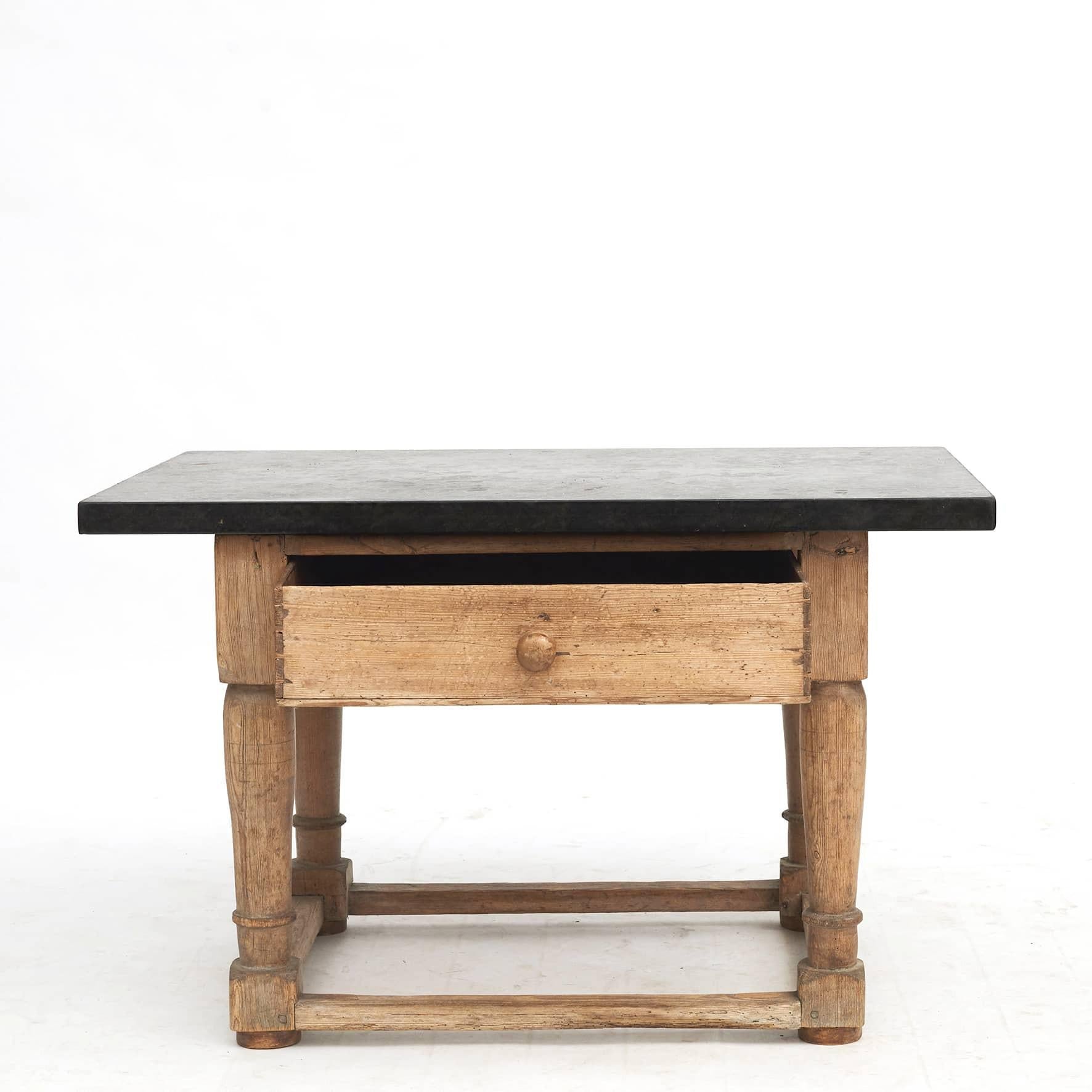 Swedish baroque table with black Jämtland limestone top. Front with drawer.
Sweden c. 1750.

Jämtland, a region in central Sweden, contains several layers of limestone in the folded mountains. Jämtland limestone is approx. 465 million years old