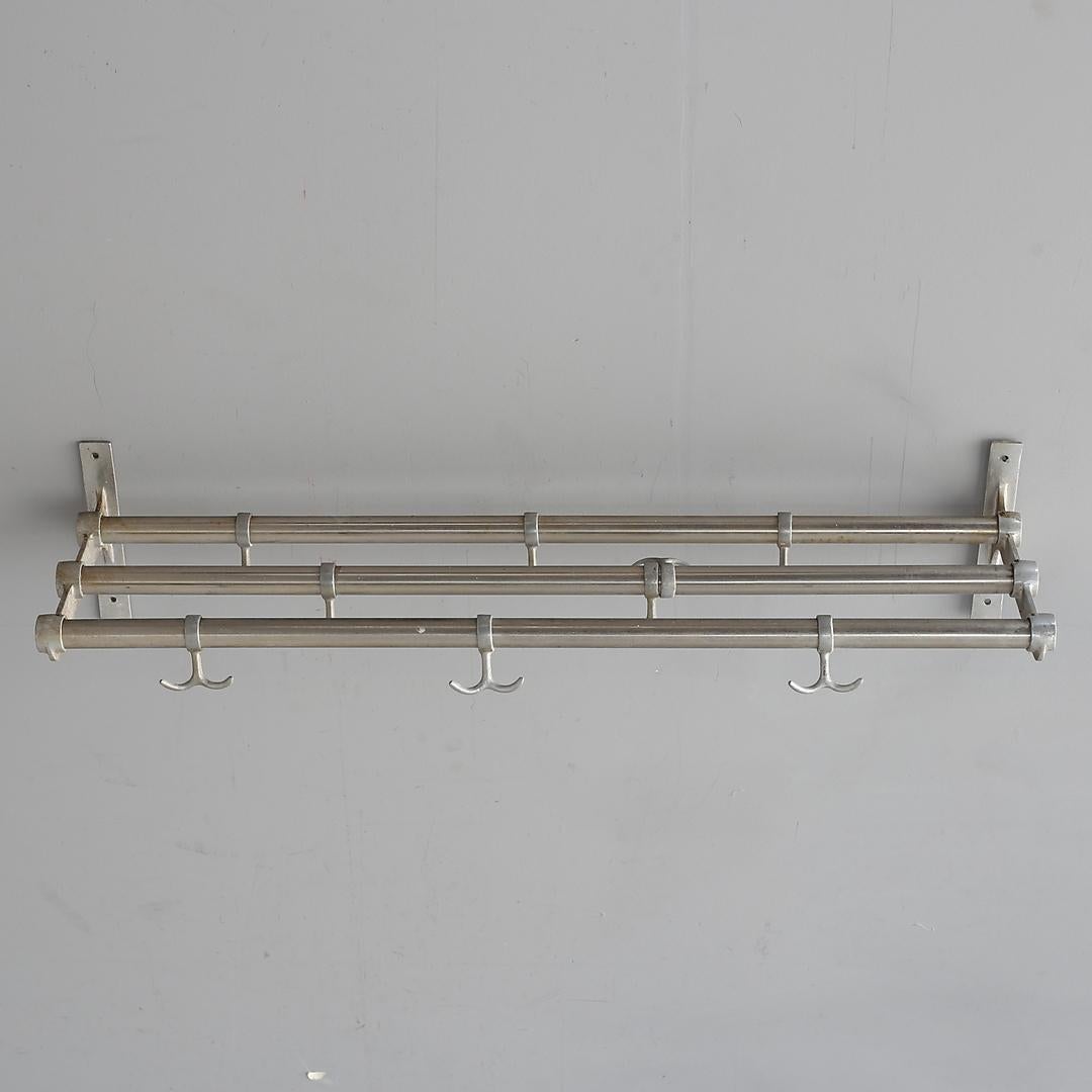 Schwedischer Bauhaus-Garderobenständer aus den Jahren 1930-1940. Halterungen und Aufhänger aus Aluminium an Aluminiumstangen.
Die Länge beträgt 84 cm und die Tiefe 26 cm.