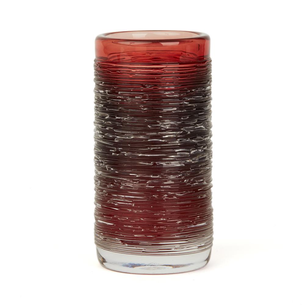 A fine vintage Swedish art glass vase of cylindrical form in red tinted glass with a clear spun glass design applied to the body by Bengt Edenfalk for Skruf. This heavily made vase is part of the 'Spun' series and is hand blown with a polished