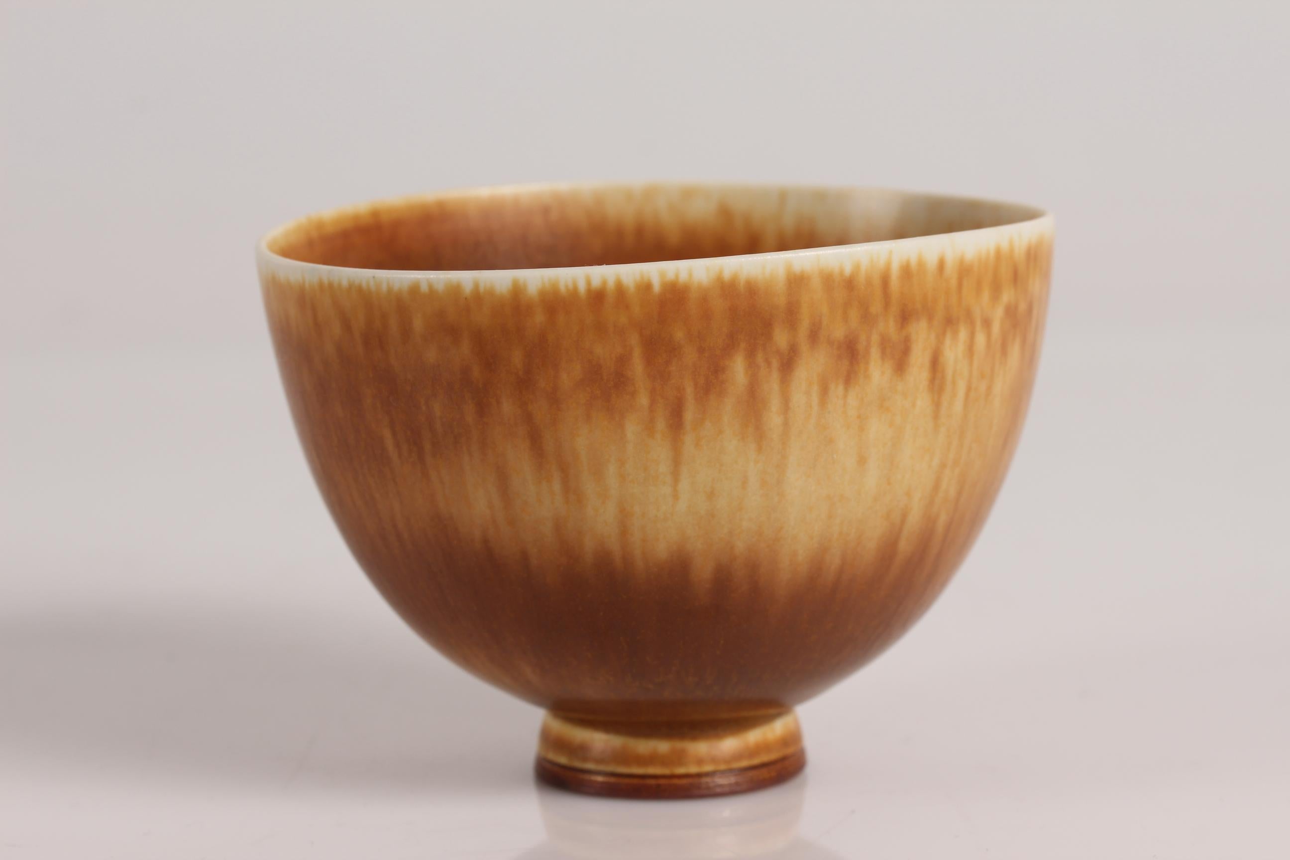 Small ceramic bowl on low foot by the Swedish ceramist Berndt Friberg (1899-1981)
The bowl, which is not quite circular, is decorated with ocher colored glaze and signed Friberg studiohand.

Measures: Height 6.9 cm
Length 9.8 cm
Width 9