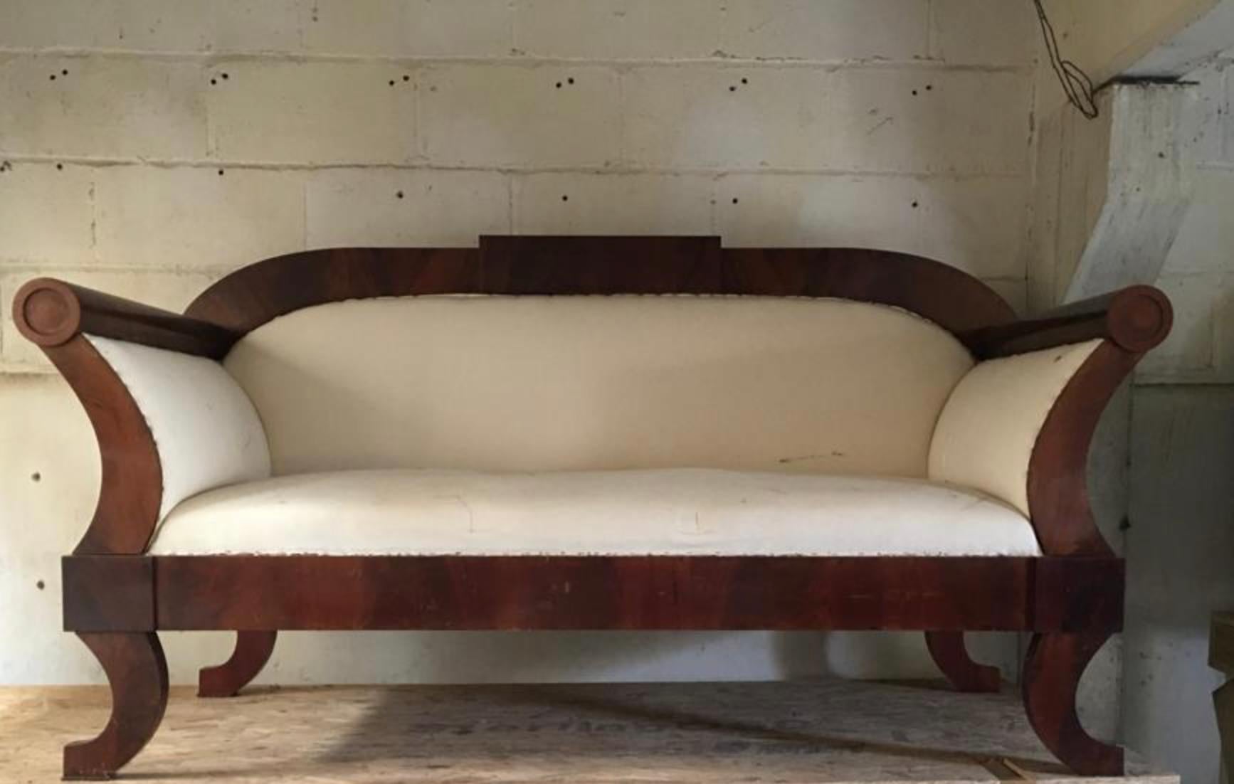 Charmant canapé trois-quatre places Biedermeier ancien sculpté, en finition polie française classique plus foncée qui fait ressortir la silhouette des placages matelassés d'acajou de qualité supérieure.

Il présente des motifs en ronde-bosse sur