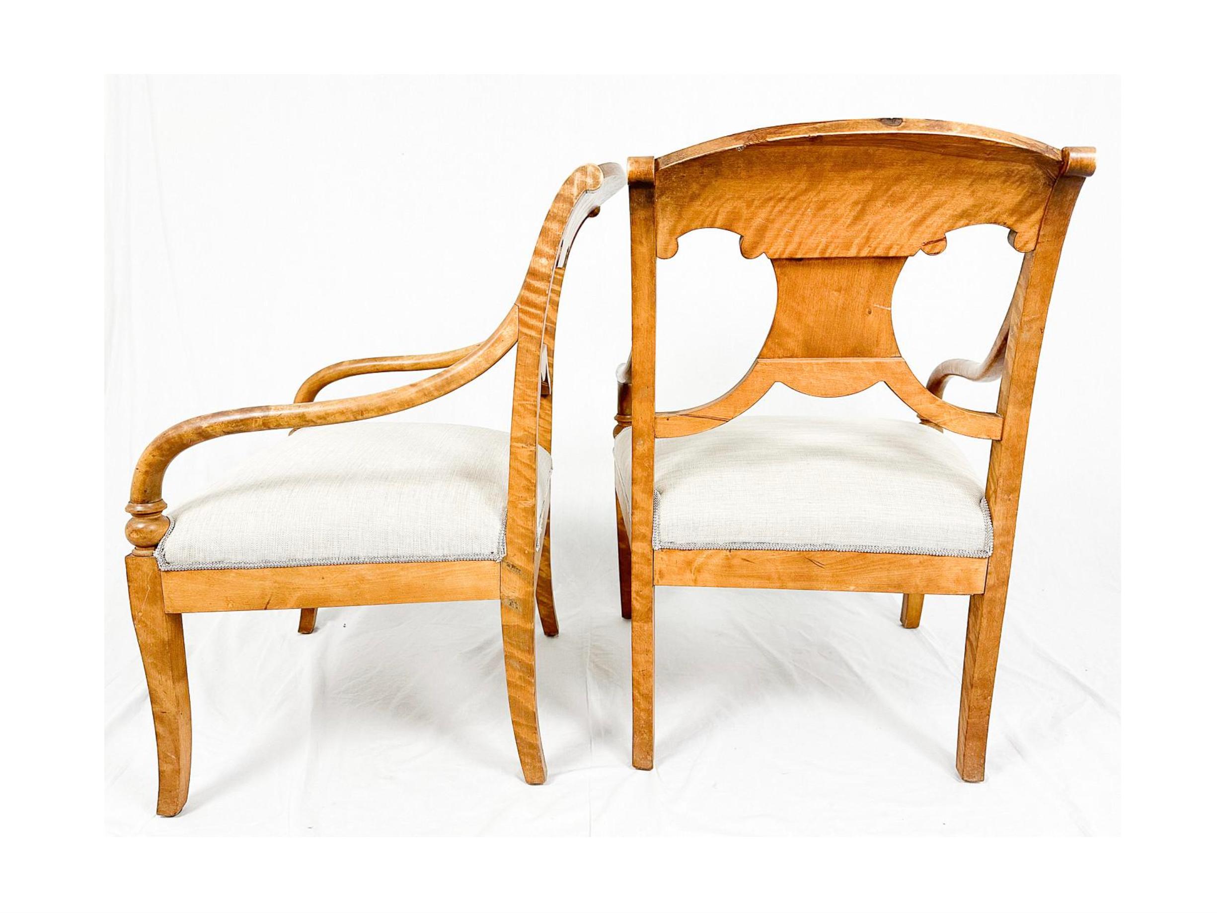 Swedish Biedermeier Empire pair of beautiful carver chairs in highest grade quilted golden birch veneers finished in the Classic honey oak color French polish finish with rounded arms.

They have fully webbed seats for maximum comfort and the gently