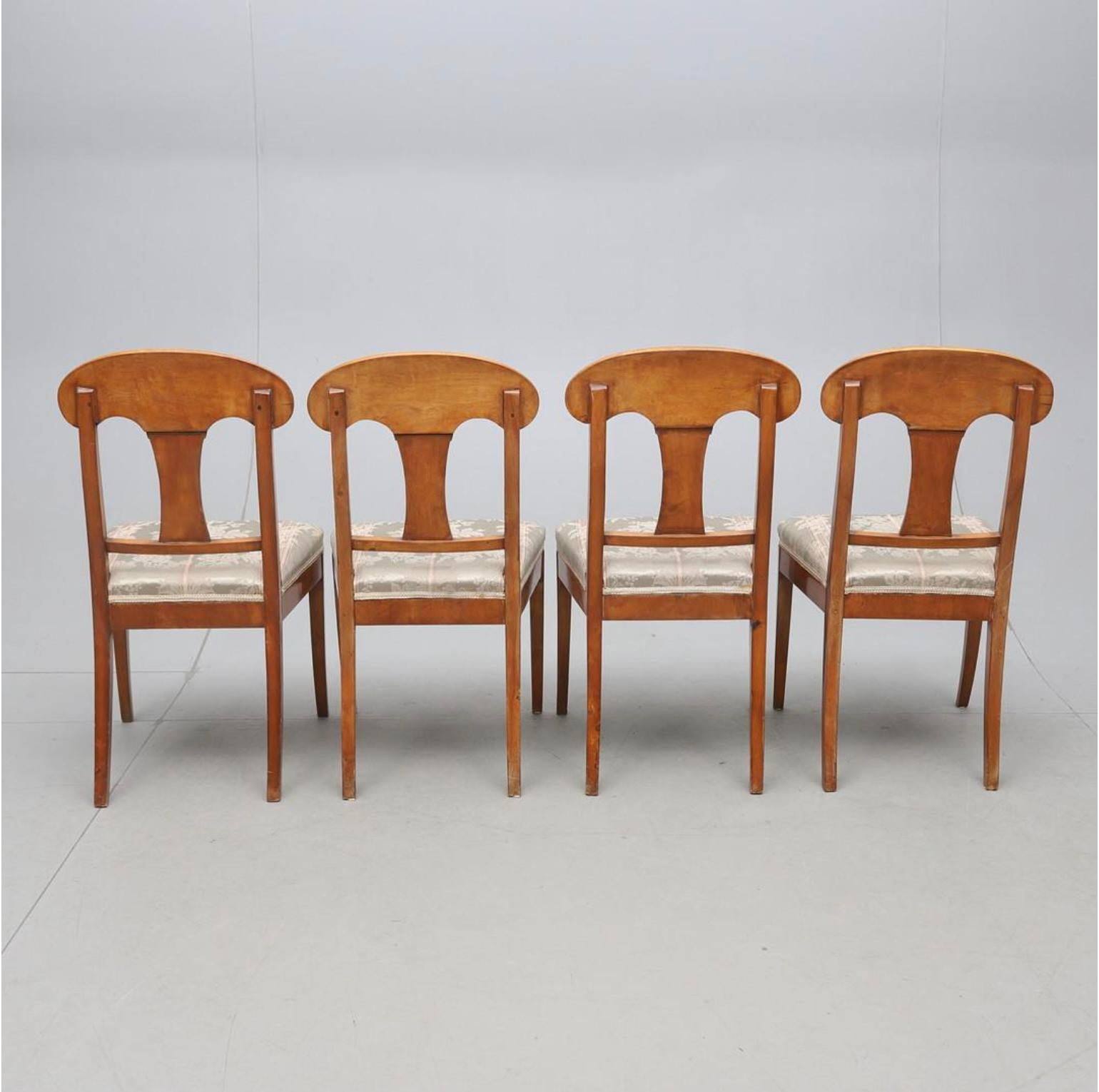 Delicious and unusual set of 4 antique Swedish flame golden birch Biedermeier dining chairs from C1870-1900 with the distinctive curved seat back, carved central motif and gracefully curved front legs.

The top grade flame veneers are brought to