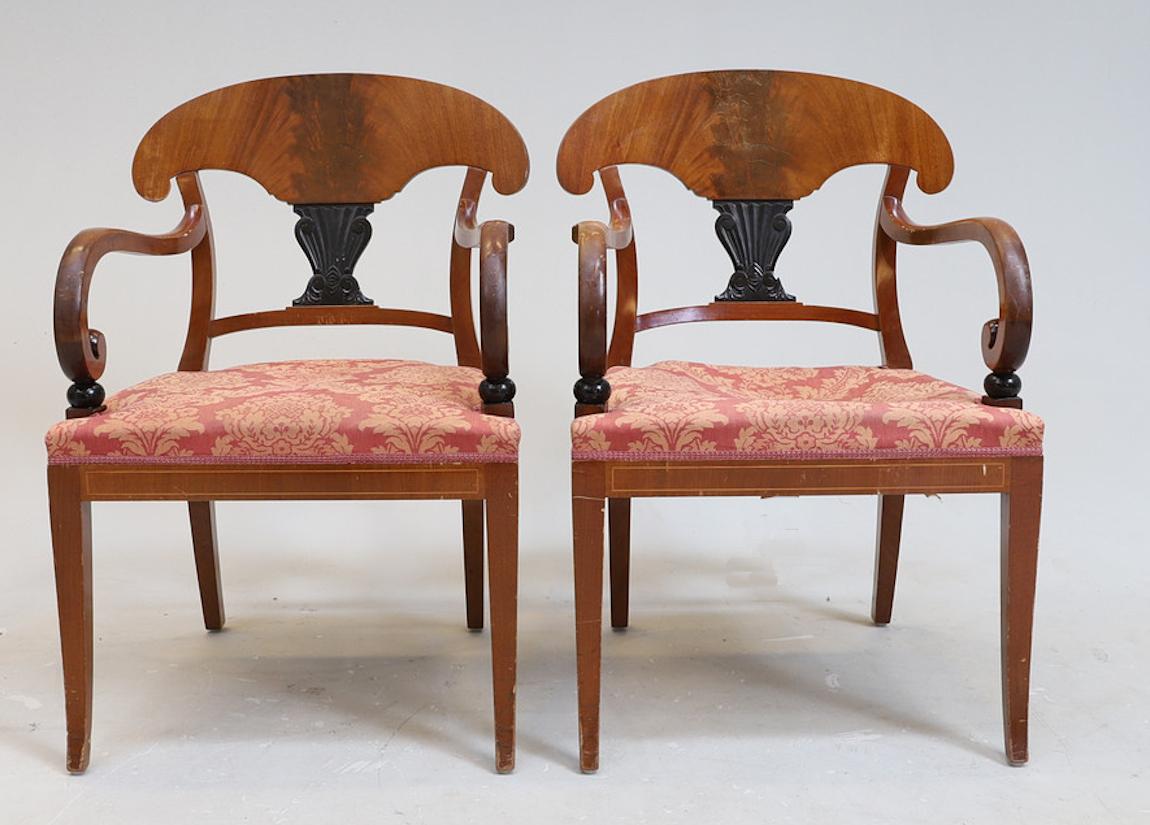 Set of 6 antique Swedish flame mahogany Biedermeier dining chairs with the distinctive curved seat back, carved central motif and gracefully curved front legs. It includes 4 chairs and 2 carver chairs.

They have lovely inlaid marquetry on the front