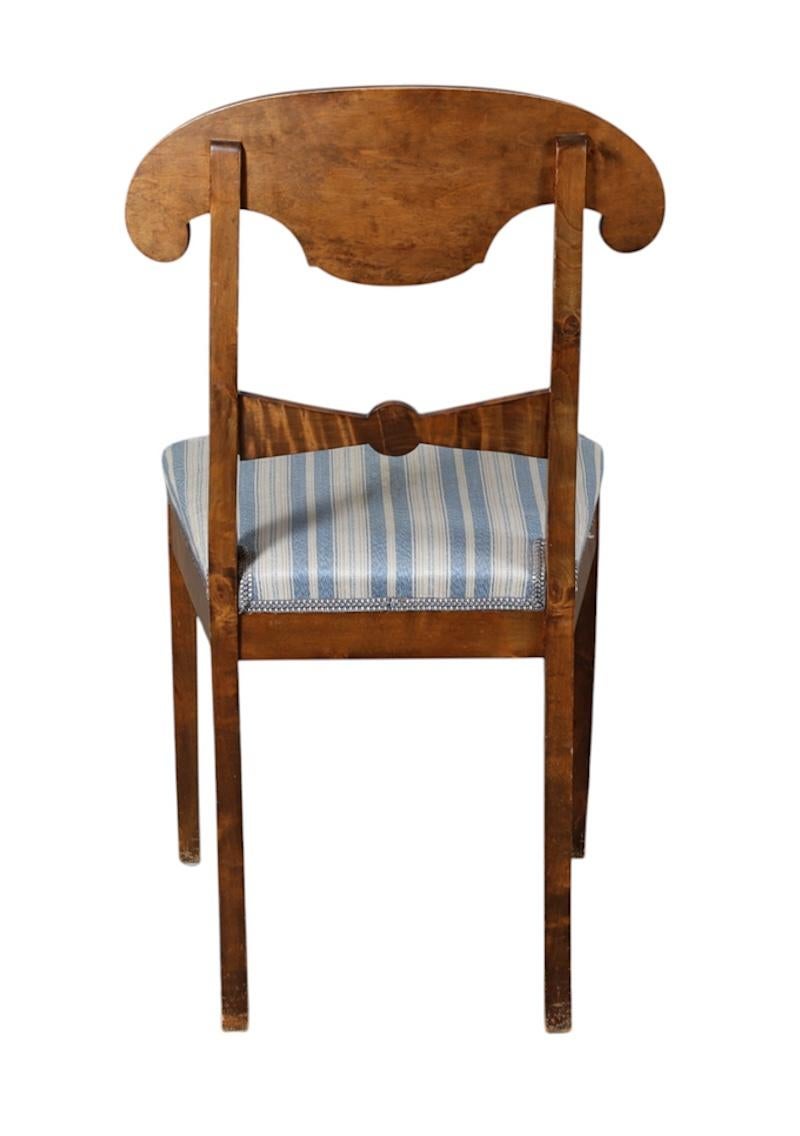 Rare set of 8 antique Swedish flame golden birch Biedermeier dining chairs from C1870-1920 with the distinctive curved seat back, carved central motif and gracefully curved front legs. Very unusual in having inlaid marquetry designs in the chair