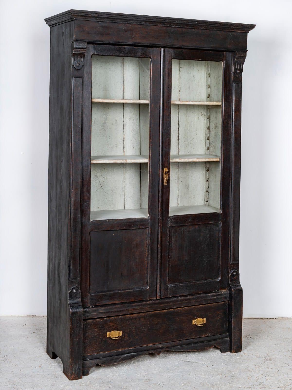 Bellissimo mobile libreria svedese Biedermeier antico con una favolosa patina nera  con dettagli intagliati su ogni lato delle porte vetrate.

Il frontale dell'armadio è caratterizzato da sontuosi dettagli intagliati e i 4 ripiani interni sono molto
