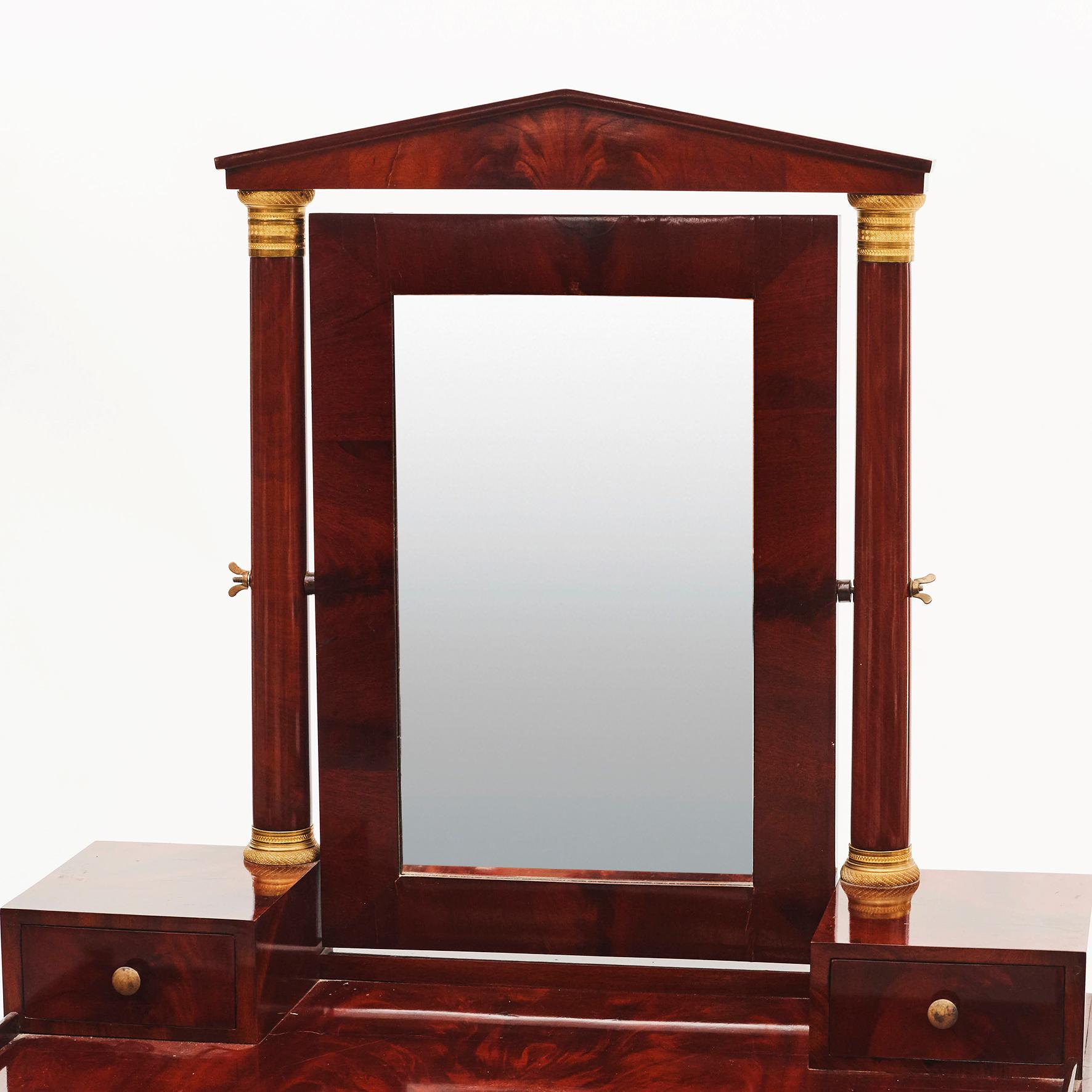 Swedish biedermeier / late empire mahogany mirrored dressing table. Swing mirror supported by gilt fluted columns, lyre shaped pedestal on brass ball feet.
Sweden, circa 1820.