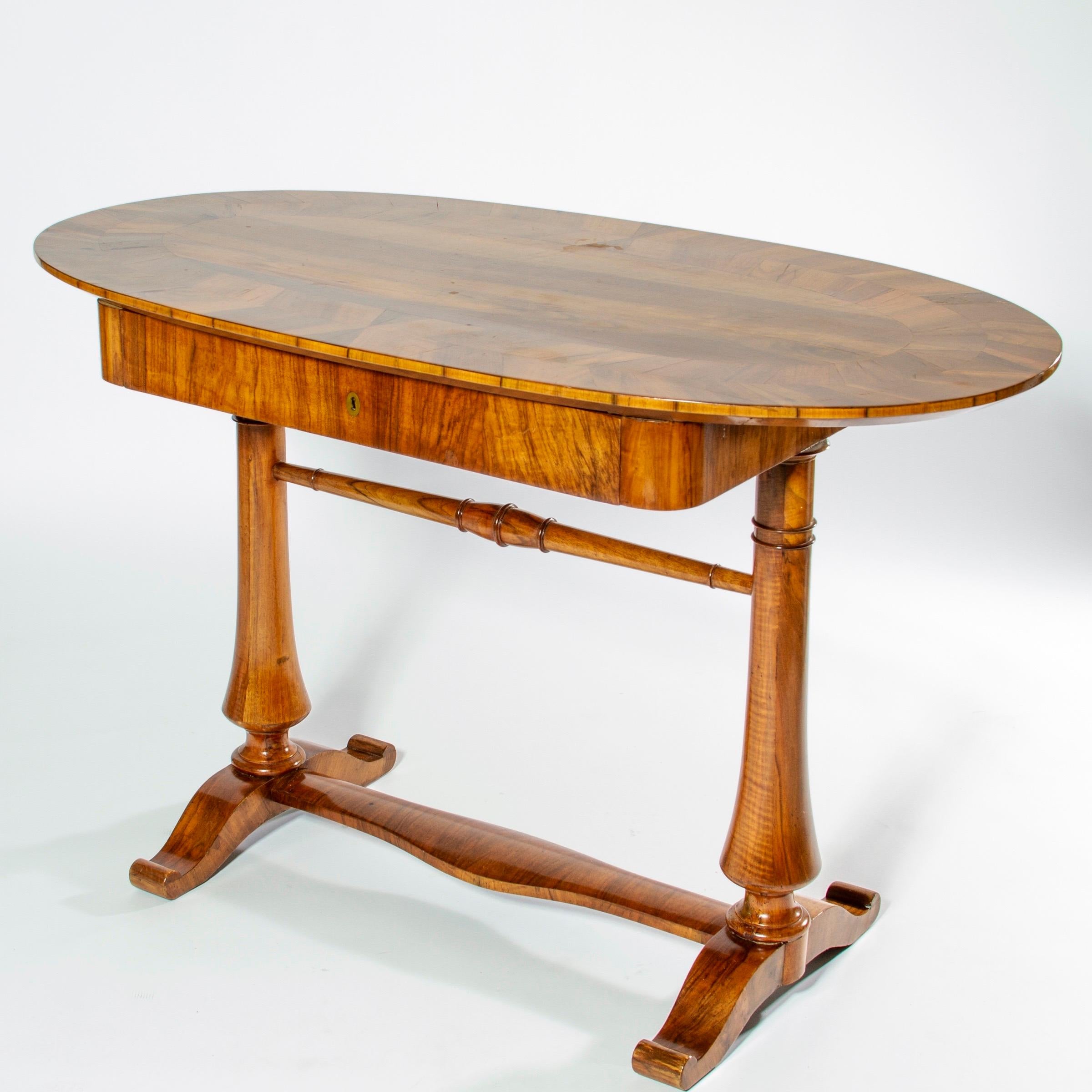 Rare Swedish Biedermeier table or desk rendered in fruitwood with an oval top and hand turned legs, Sweden.