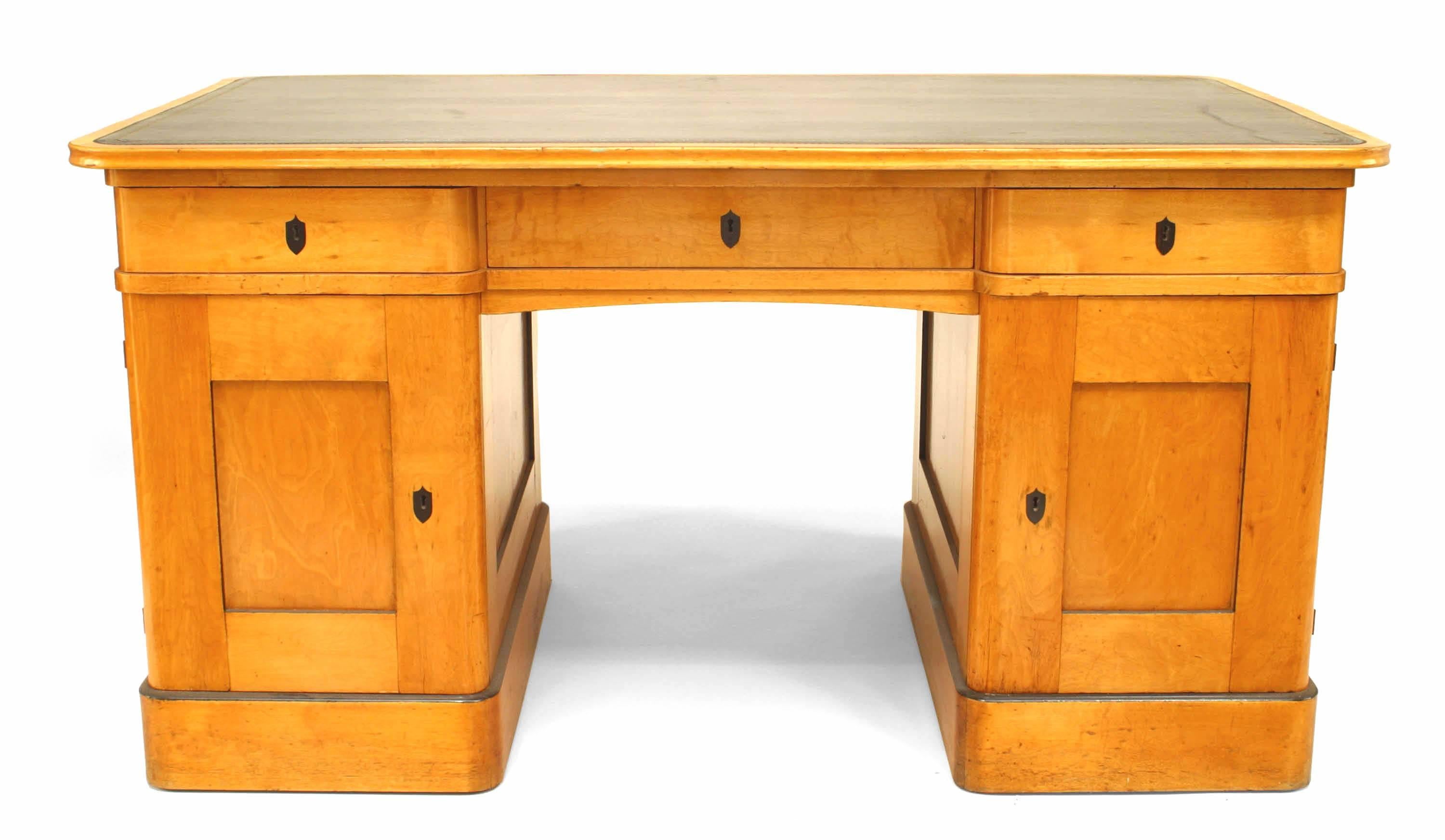 Swedish Biedermeier style (19/20th Century) birch and black trimmed kneehole desk with black leather top.
