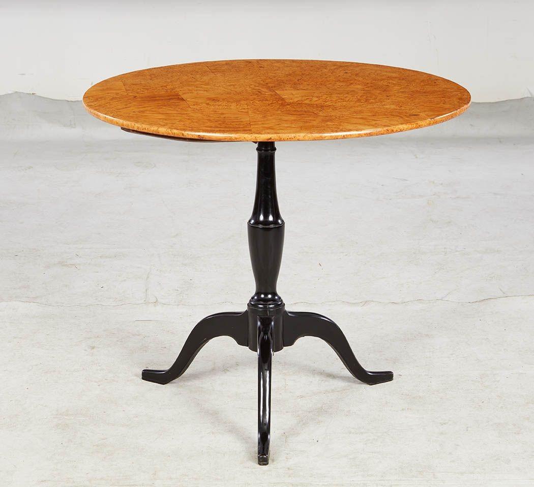 Table tripode suédoise du début du XIXe siècle, le plateau rond plaqué de loupe de bouleau au grain et à la couleur très vifs, reposant sur une base tripode ébonisée à tige vasiforme et à pieds cabriole façonnés.