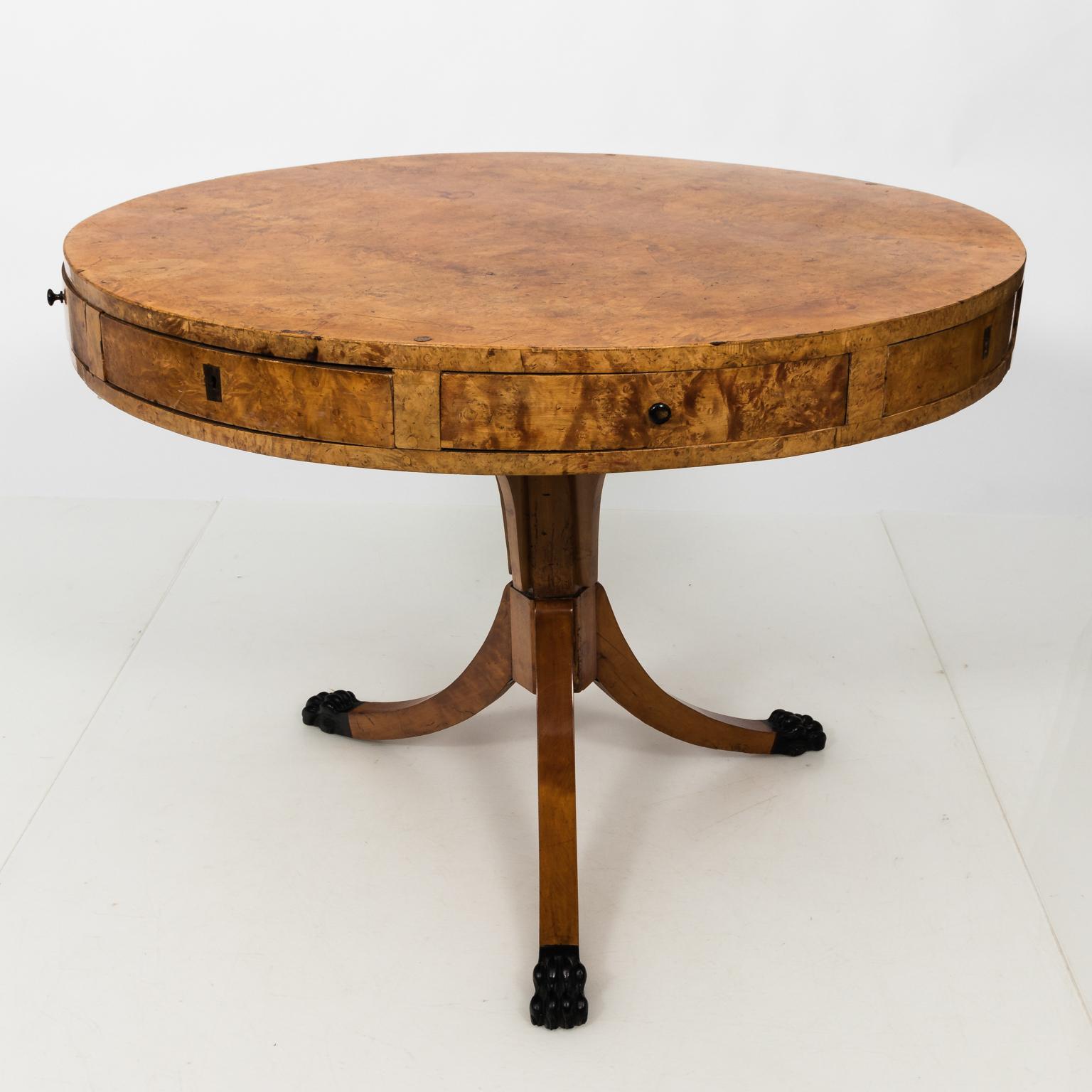 Round birchwood and birch root center table in the Empire style with drawers, circa 1890. The tripod base also features carved black painted lion's paw feet.
 