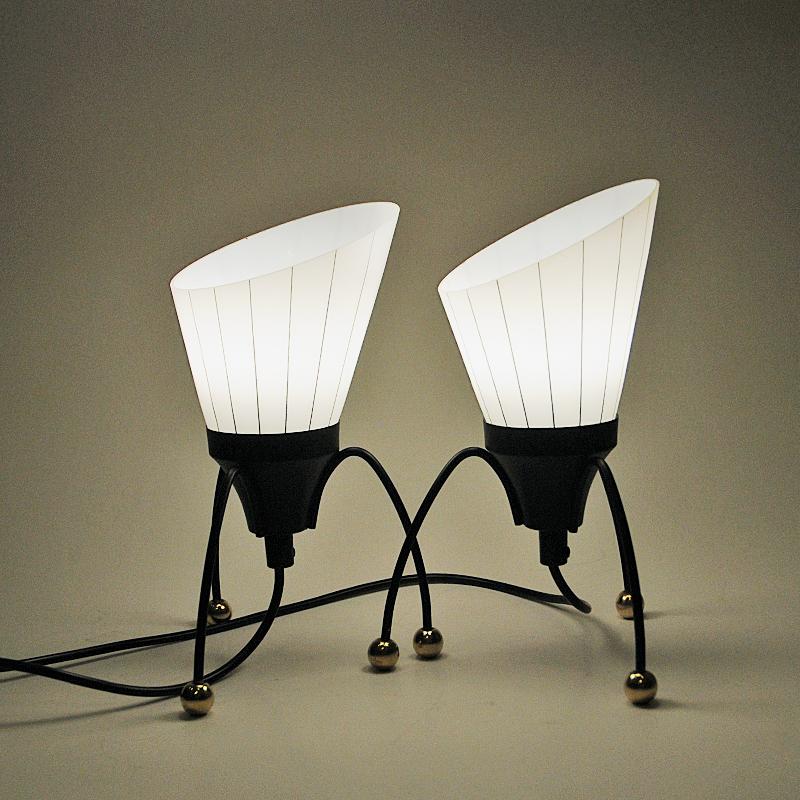 Black metal tablelamp pair with removable cone shaped glass shades by Edward Hagman for Ehab - Sweden 1950s. The glass shade are frosted with clear stripes in between. Triangle shaped spider inspired metal legs with brass button ends and a black
