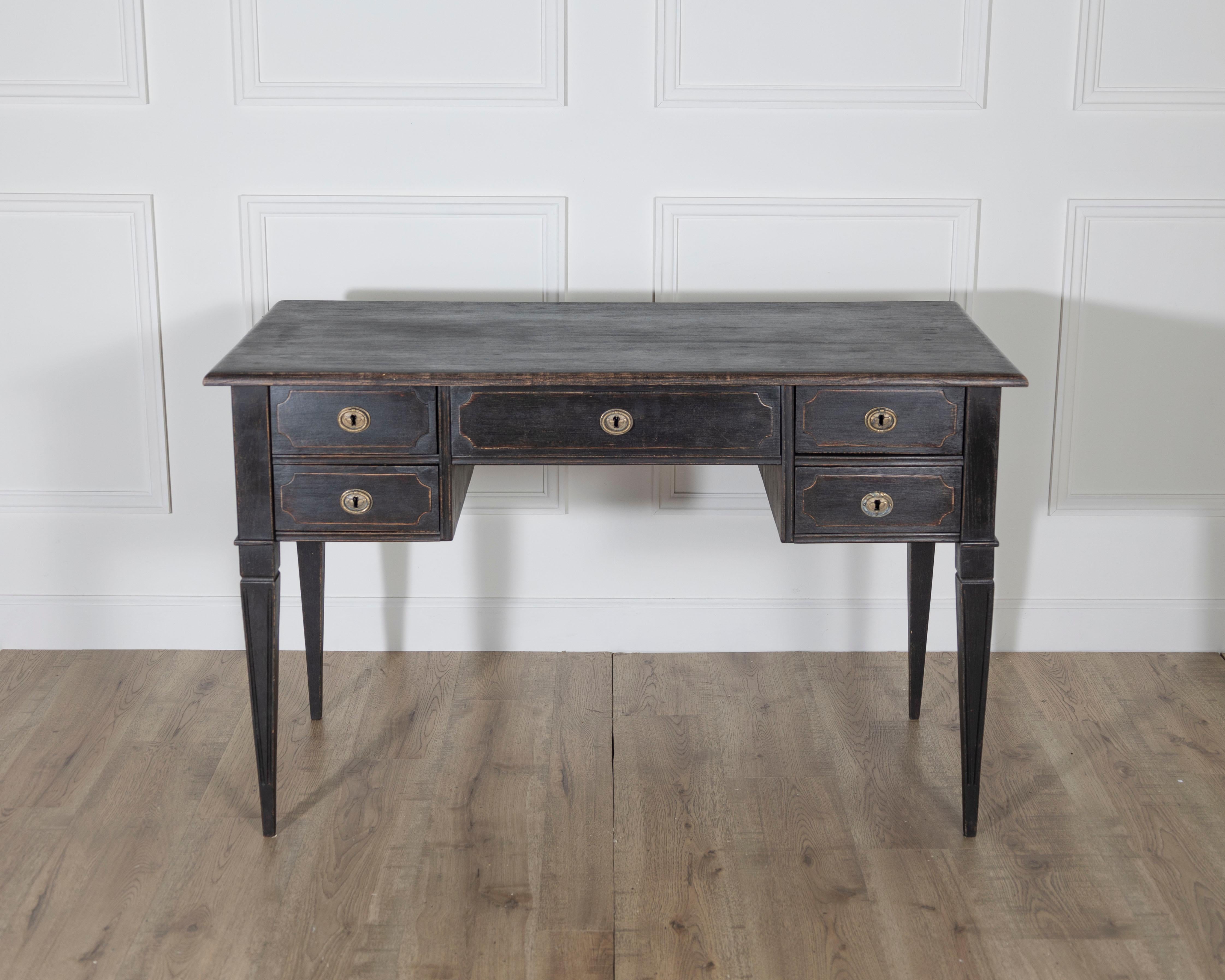 A handsome antique Swedish writing desk, crafted in pine and painted in a deep black with a soft, aged patina. Dating from circa 1870–1890, this desk features a generous work surface supported by five functional drawers, two on each side and one