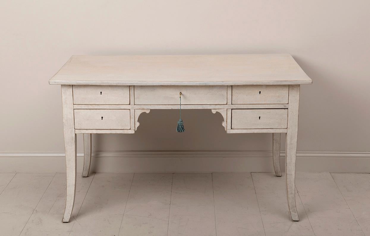 A Swedish writing desk from the 1920's that has been bleached and lime washed creating a beautiful patina. Plenty of storage with 4 deep drawers on the sides and 1 long center drawer. The apron height/knee clearance is 23.63 inches H. The side