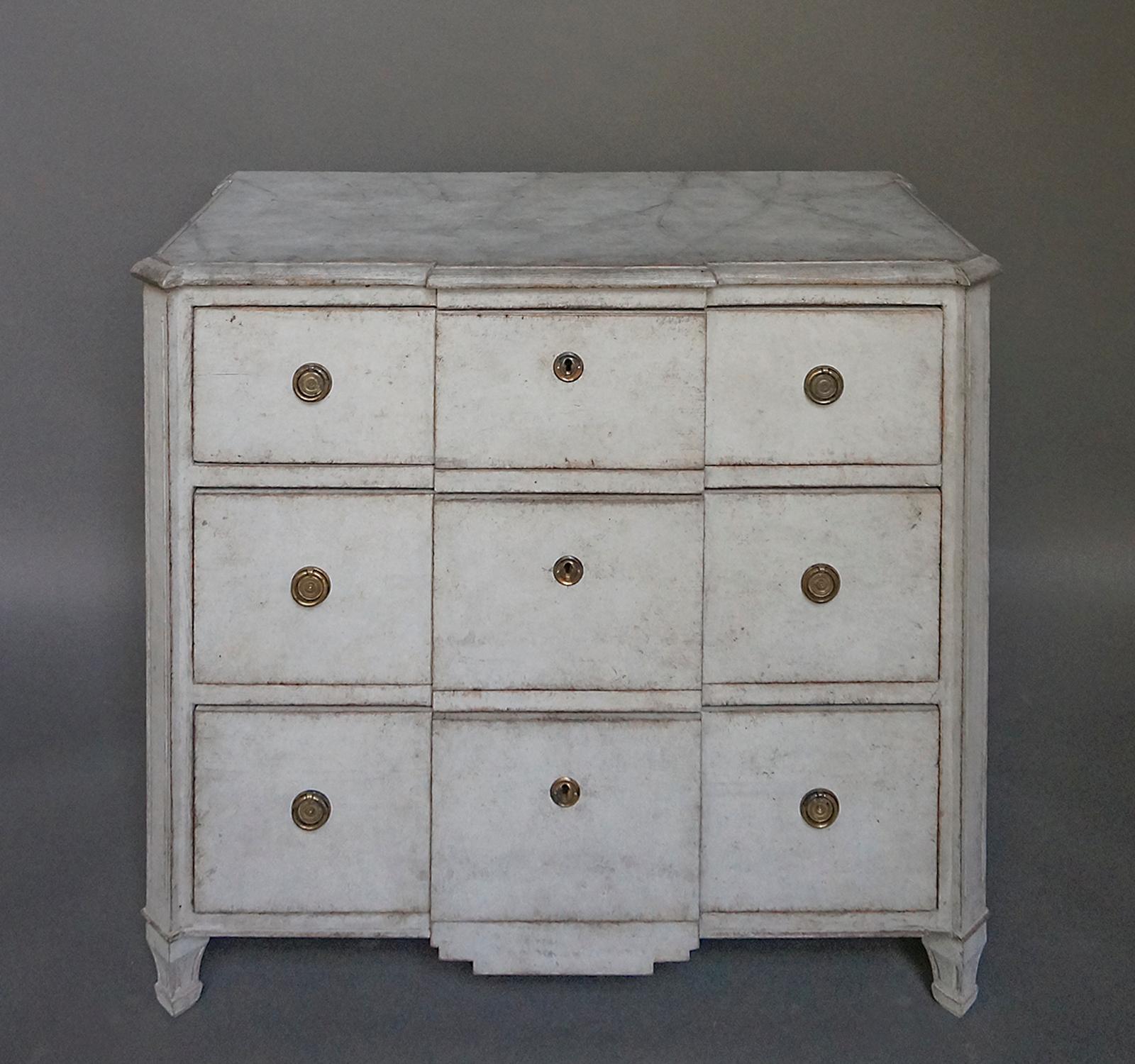 Simple Swedish commode, circa 1910, with three drawers, a block front and a decorative shaped apron. The top is painted with a smoky marbled pattern. A single key opens all three drawers.