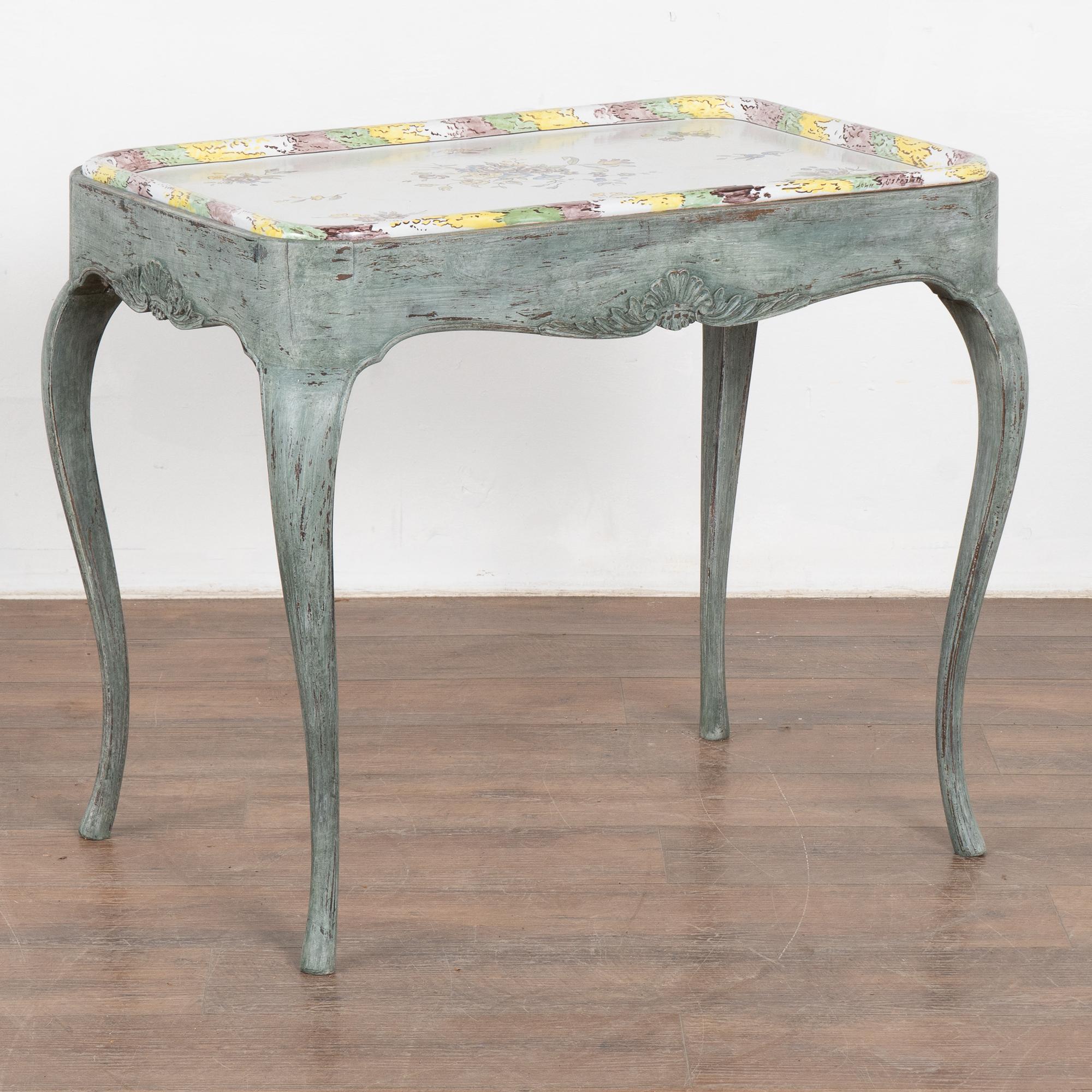 The elongated cabriolet legs add a charming touch to this side table that originally served as a tea table in Sweden.
Restored, later professionally painted in layered shades of blue and lightly distressed to fit the age and grace of this lovely