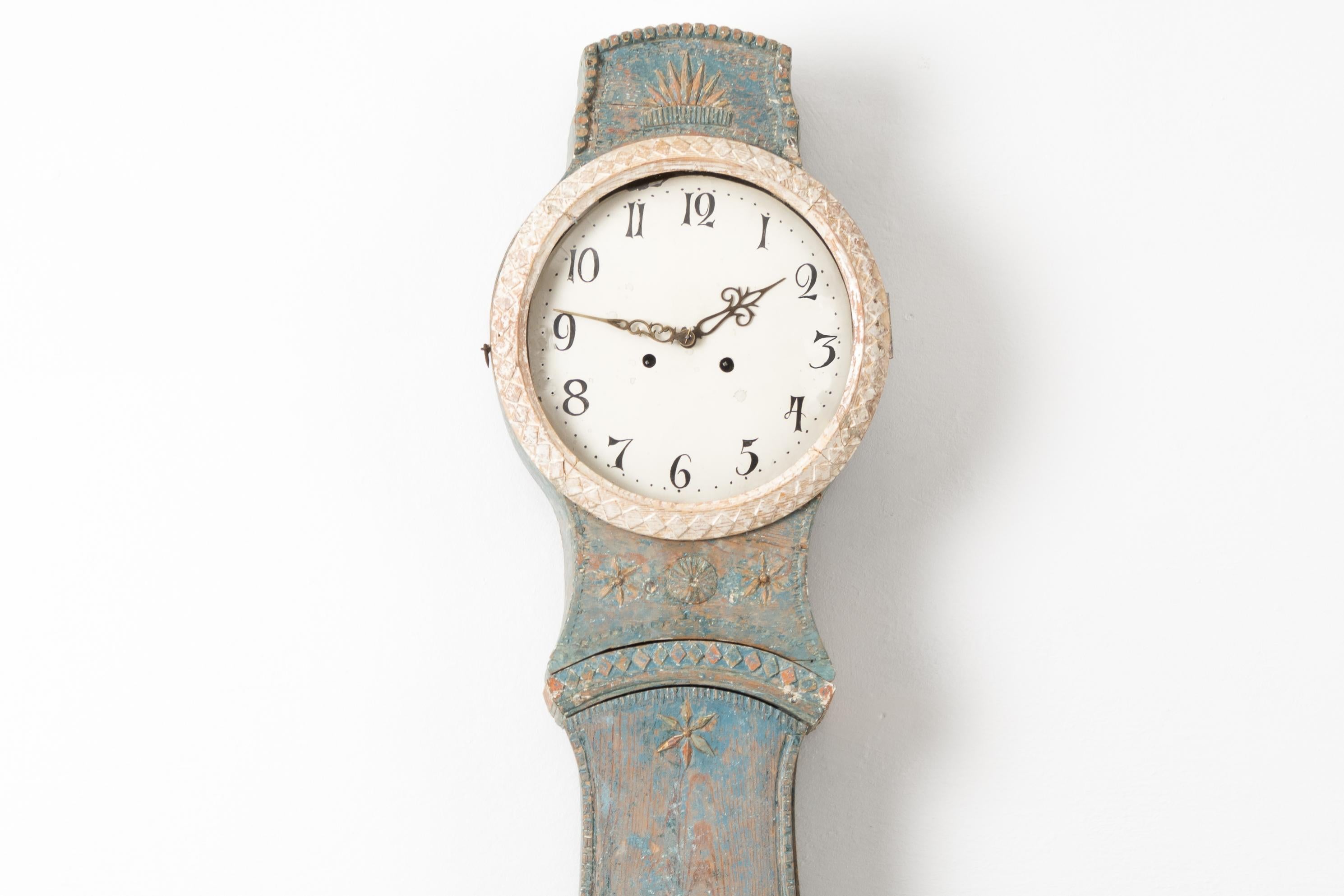 Ländliche Mora-Uhr im Rokoko-Stil aus Nordschweden. Die Uhr ist aus bemalter Kiefer gefertigt und stammt aus der ersten Hälfte des 19. Jahrhunderts, etwa 1820 bis 1830. Die blaue Farbe ist ein Original aus den frühen 1800er Jahren. Verziert mit