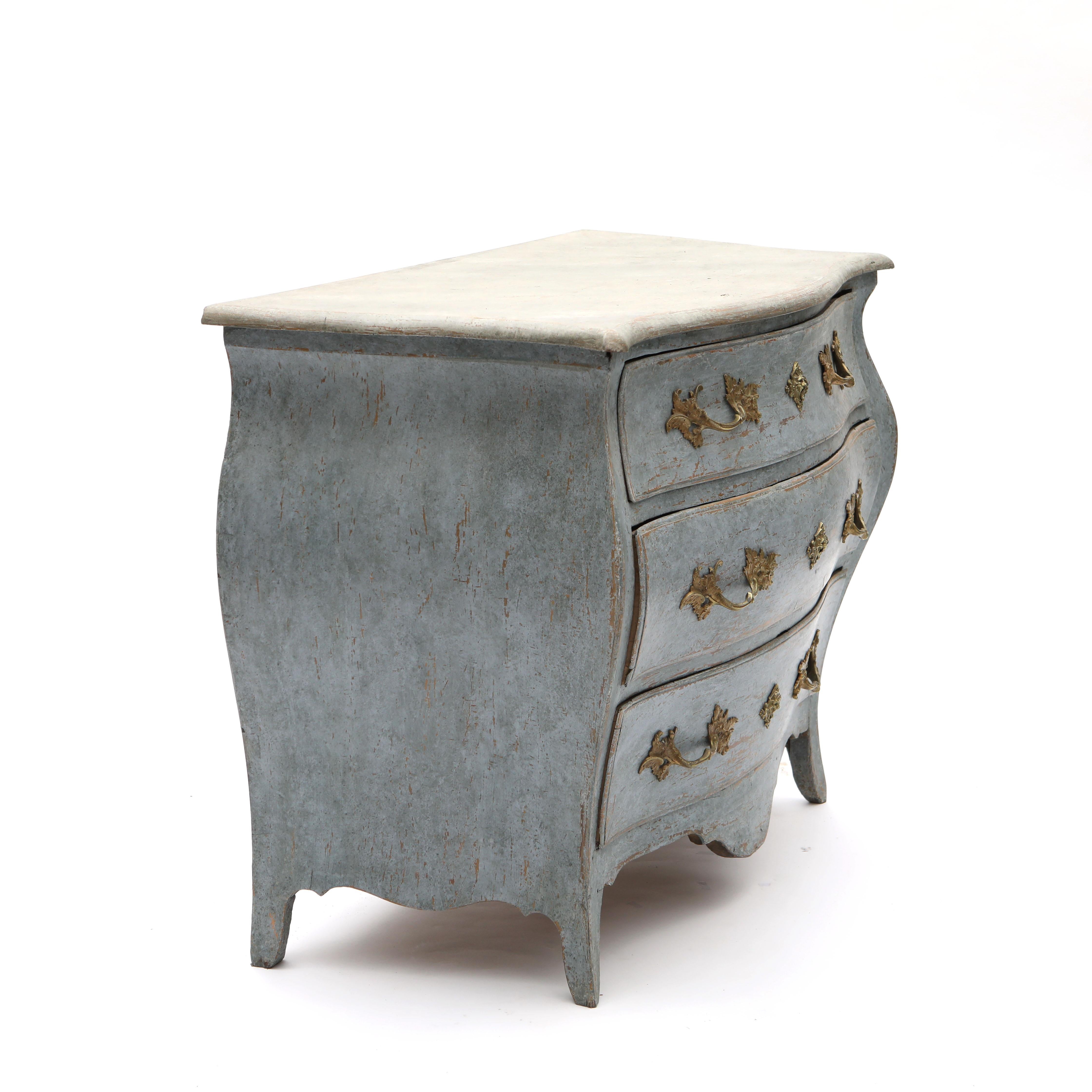 Elegant Swedish bombé-shaped rococo chest of drawers with a curved front and sides.
The chest of drawers has three spacious drawers, all with their original gilded bronze fittings.
Body in a dove blue color with a beautiful patina that stands in