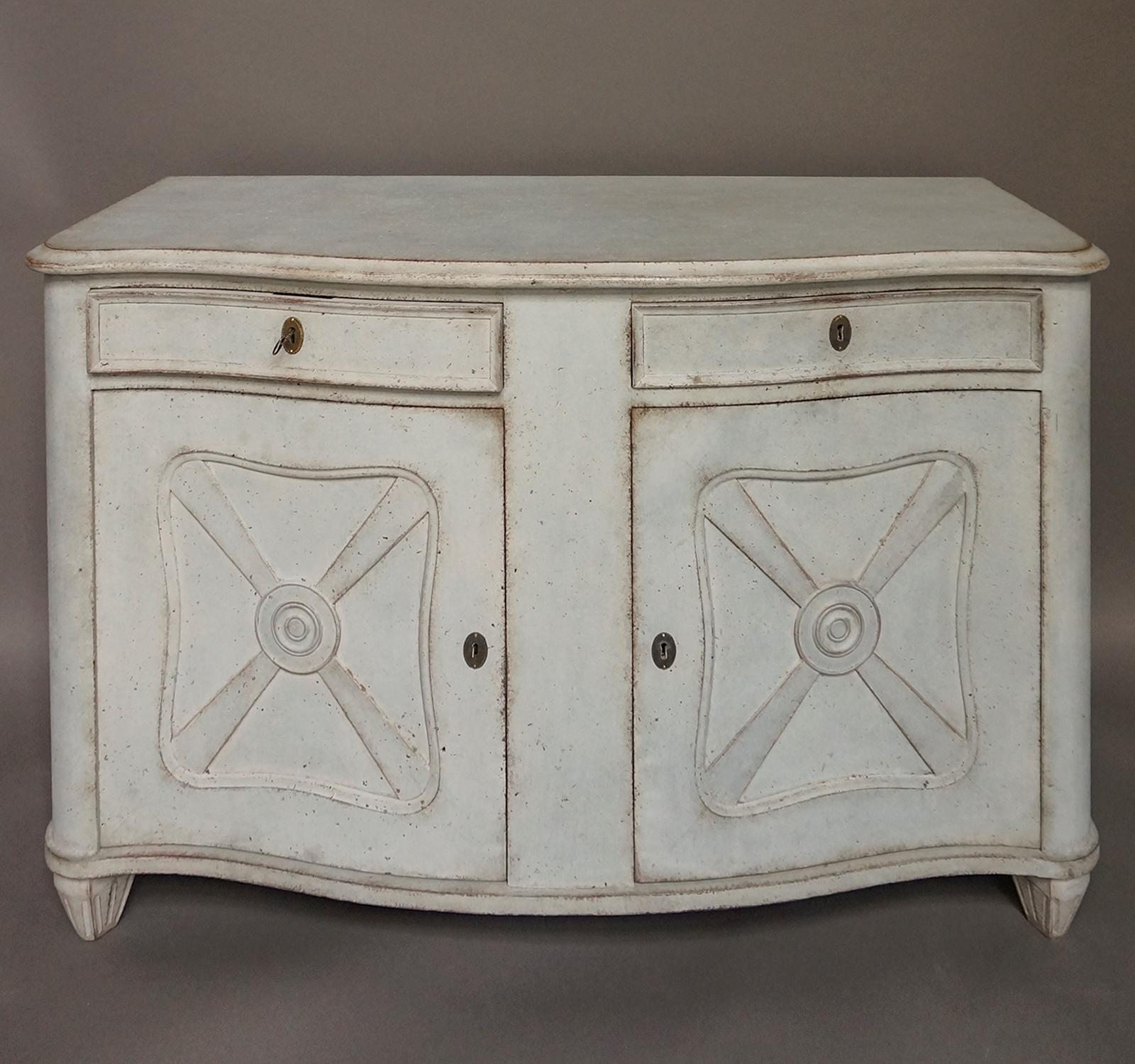 Unusual sideboard, Sweden, circa 1910, with rounded corners and curved front. Recessed panels on both the drawer and door fronts. Open interior with a single fixed shelf on each side. Tapering square feet.