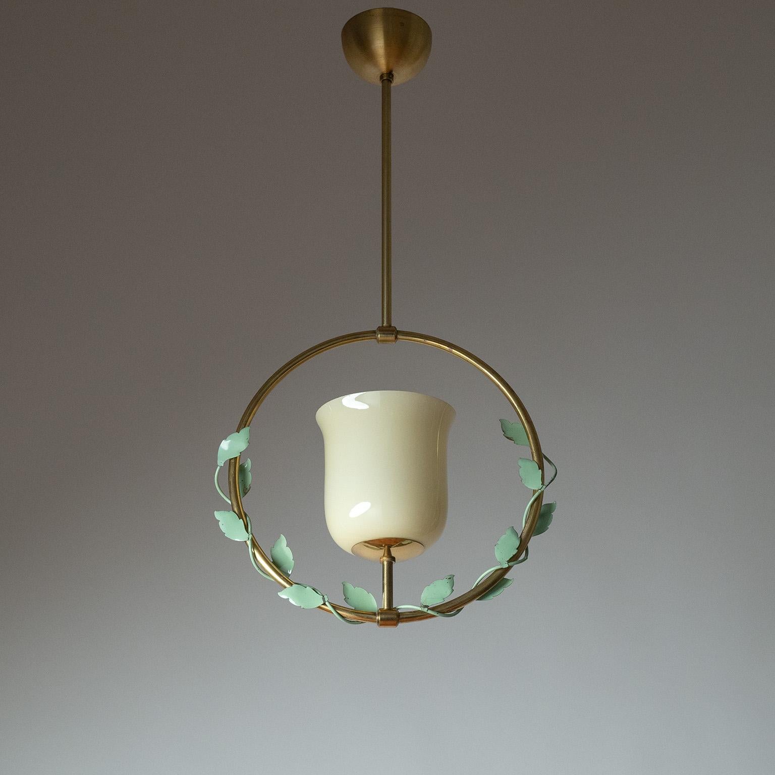 Colgante sueco de latón y cristal de la década de 1940. Un tulipán de vidrio soplado de color arena está rodeado por un marco de latón con adornos de hojas de hierro pintadas. Muy buen estado original con algo de pátina en el latón y pintura