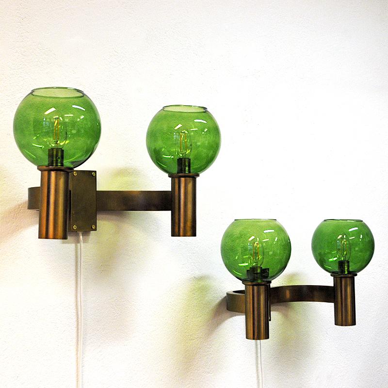 Midcentury brass double wall lamp pair with lovely light green glass shades from Sweden 1960s. Gives a great calming light and a pleasant shine into the room. Great light green color. Solid brass stoms. Measure: 24 cmH x 45 cmW x 23 cmD. Brass