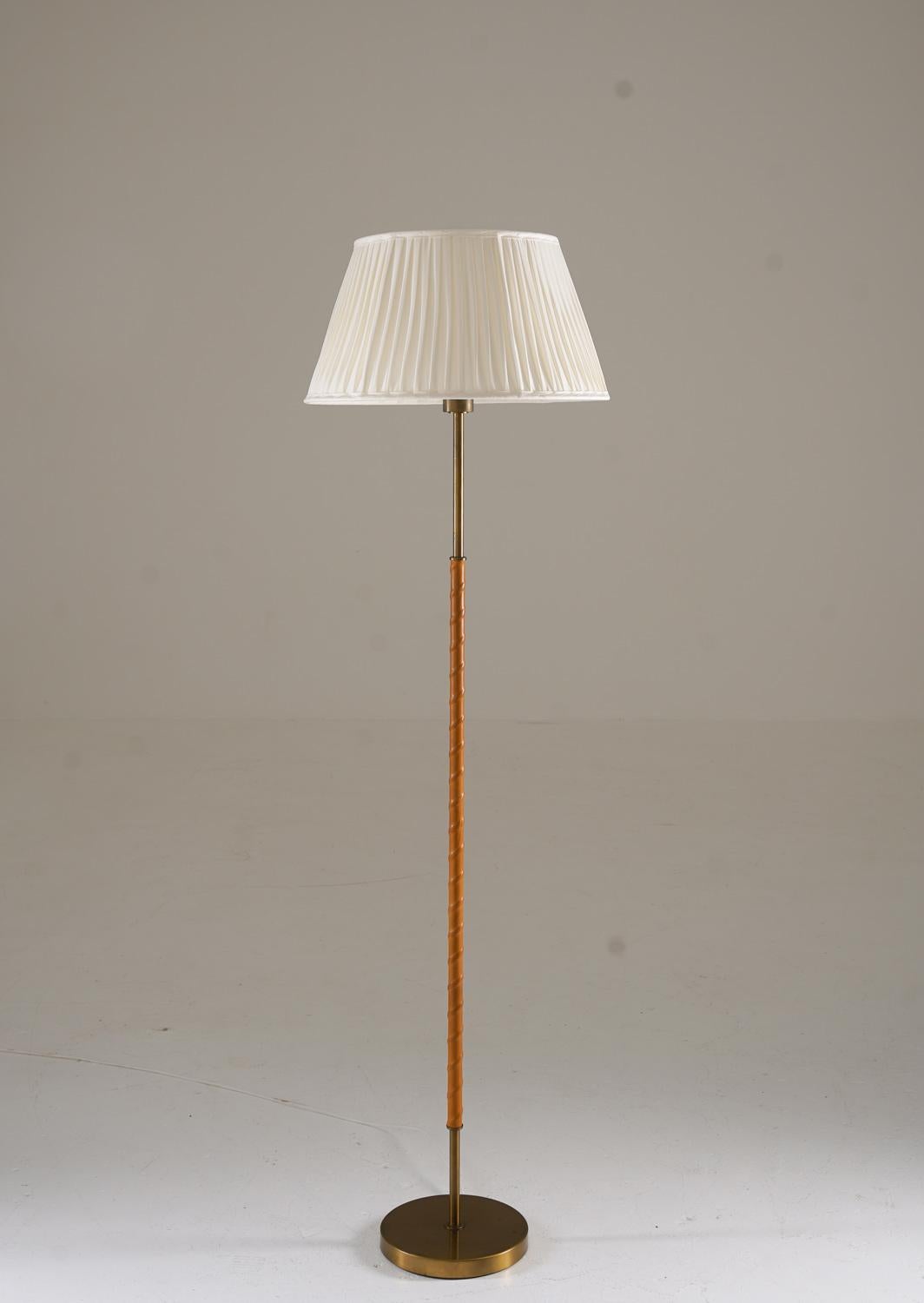 Lampada da terra scandinava, prodotta da Böhlmarks in Svezia negli anni Cinquanta. Questo pezzo di alta qualità mette in mostra l'artigianato dell'epoca, con un'elegante struttura in ottone abbinata a fettucce in pelle finemente lavorate. La
