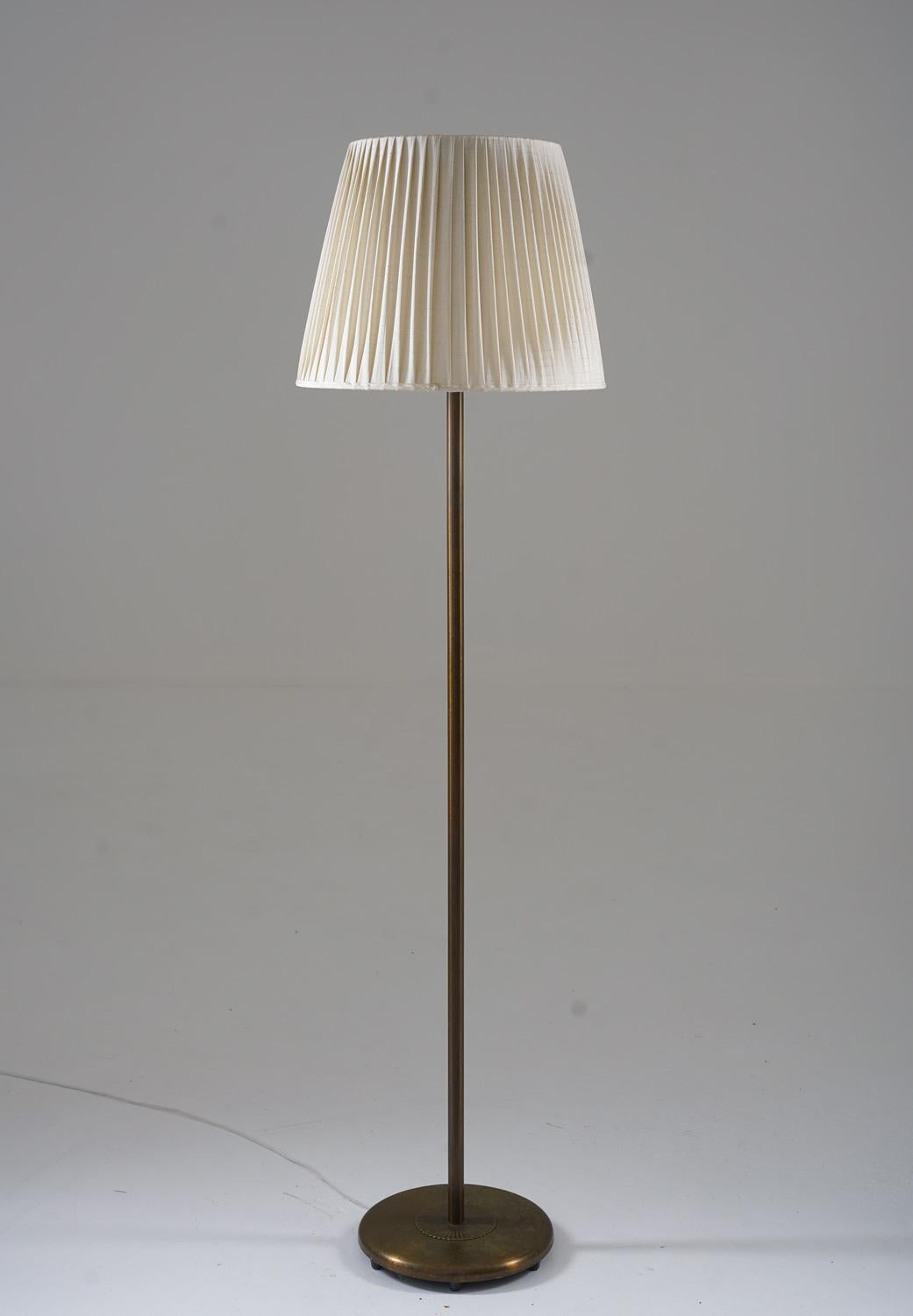 Large Scandinavian floor lamp model 15370, manufactured by Böhlmarks, Sweden, 1940s.
This heavy lamp is made of solid brass, with beautiful details, such as the pattern on the base. 

Condition: Very good original condition with perfect patina on