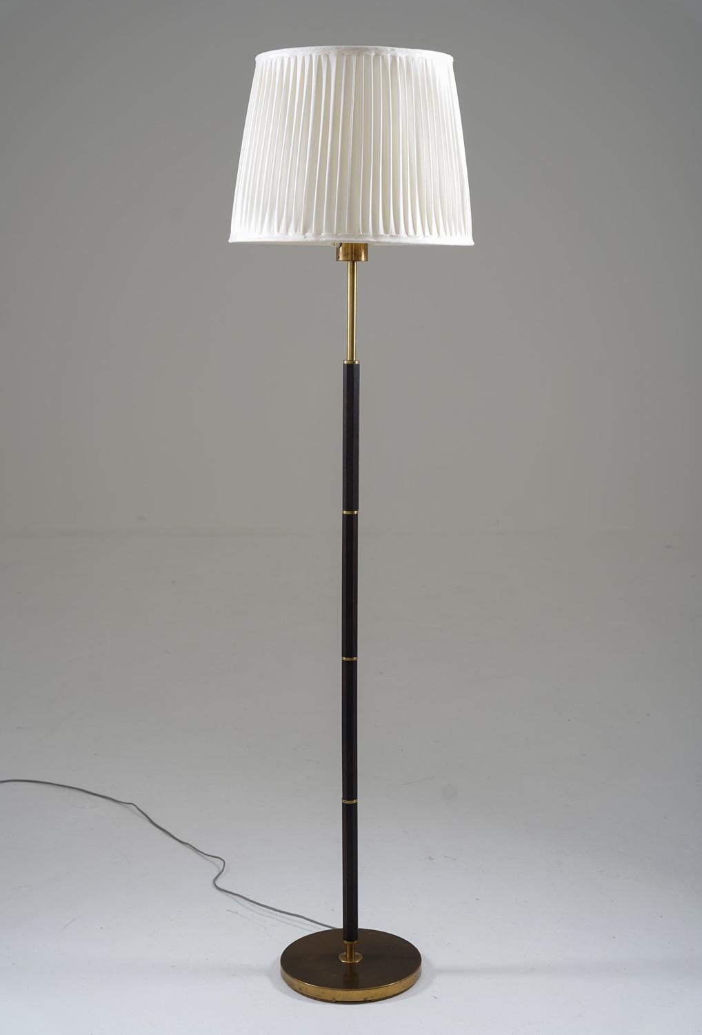 Large Scandinavian floor lamp manufactured by Boréns, Sweden, 1960s.
This lamp is made of brass and rosewood, with four light sources; one uplight and three downlights. 

Condition: Very good condition. New custom-made hand-pleated chintz fabric