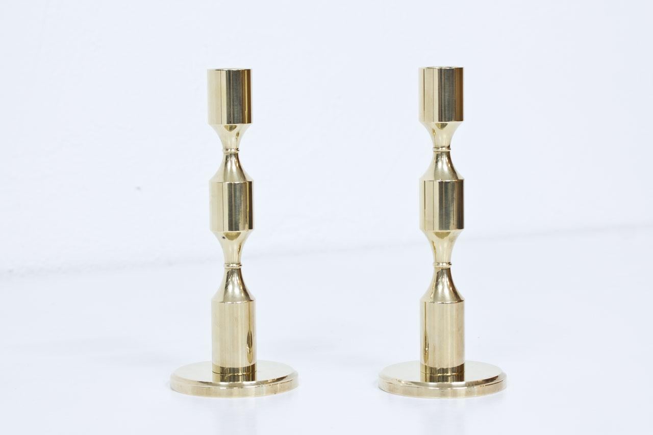 Pair of solid and heavy polished brass candleholders. Manufactured by Gusum in Sweden. Engraved and dated 1978-79. Suitable for large candles (2cm diameter).