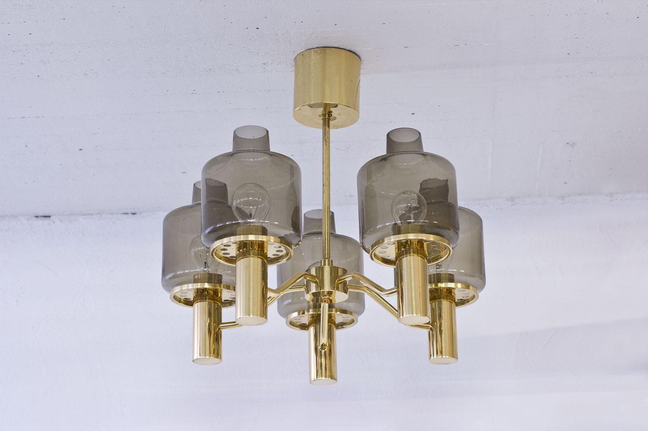 Beautiful T 507 “PRIOR” chandelier designed by Hans-Agne Jakobsson, 
manufactured by his own company in Markaryd, Sweden during the 1960s. 
Polished brass structure with five arms, light smoke colored glass shades.

Very good vintage condition,