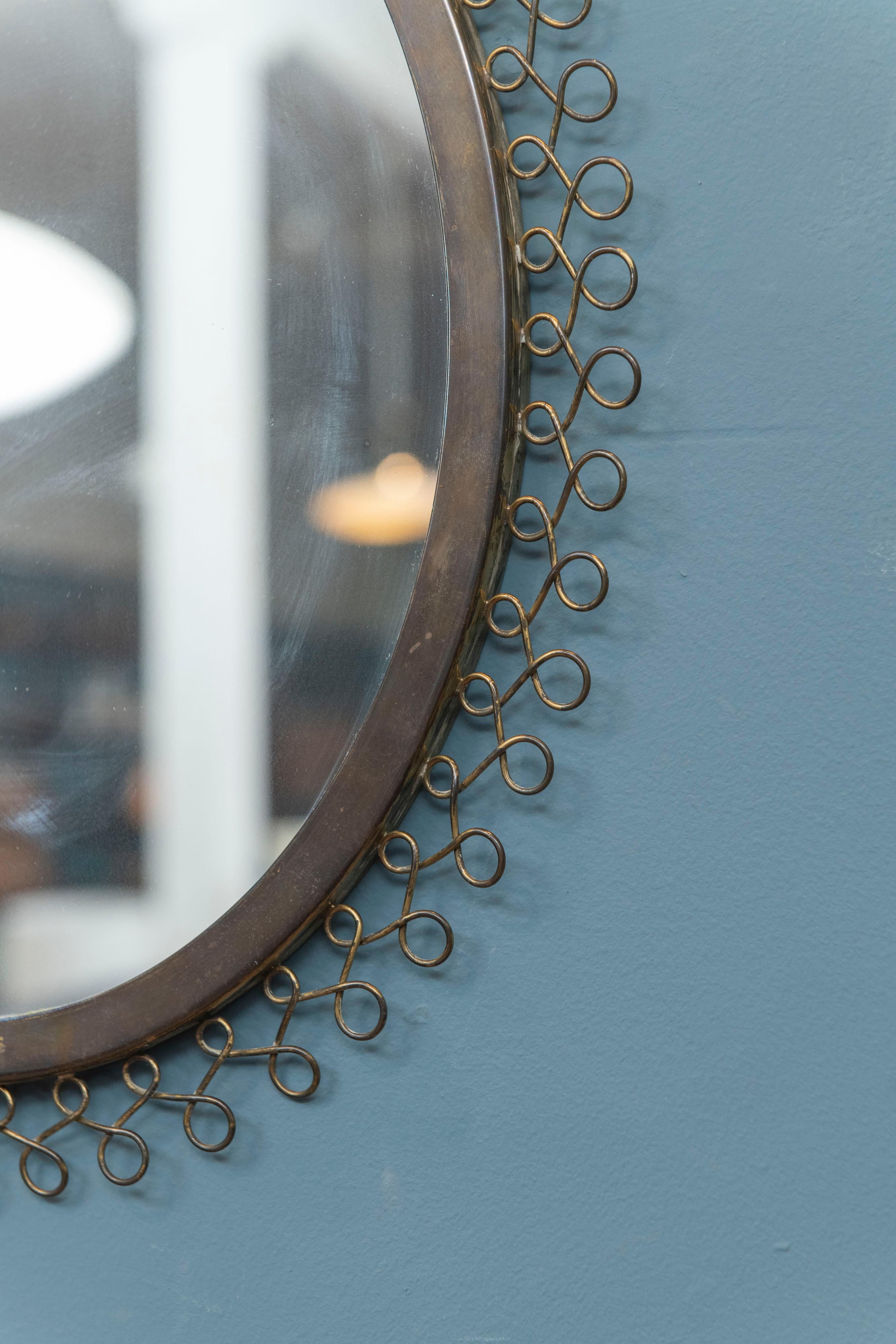 Scandinavian modern oval brass wall mirror made with looping decorative fretwork, made in Sweden.
