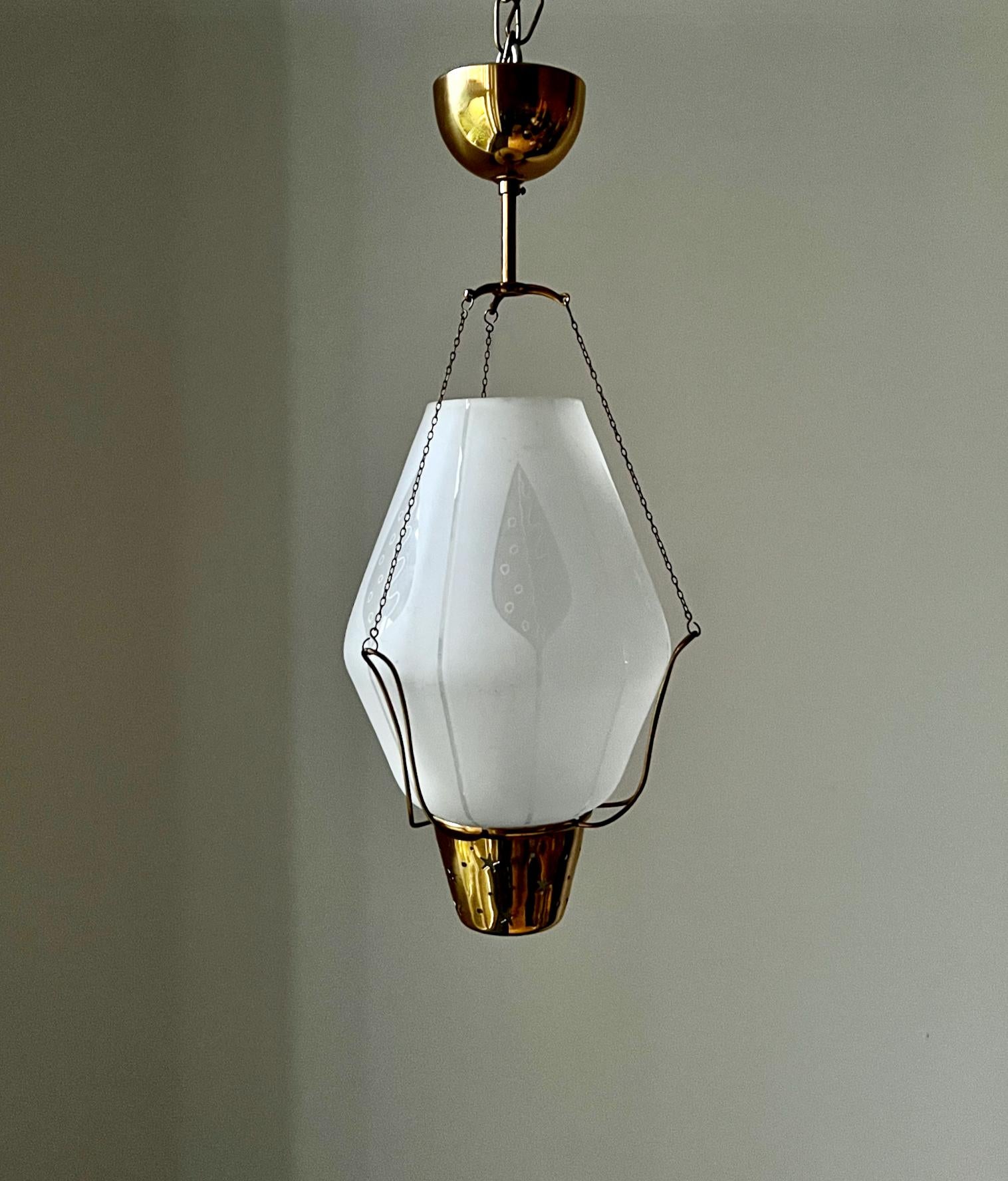 A Swedish brass pendant light with etched glass shade and openwork details. Mid-20th century, designer unknown.

A nicely made piece with a thick glass shade held by a brass frame and three delicate loops and chains. Simple leaf designs are etched